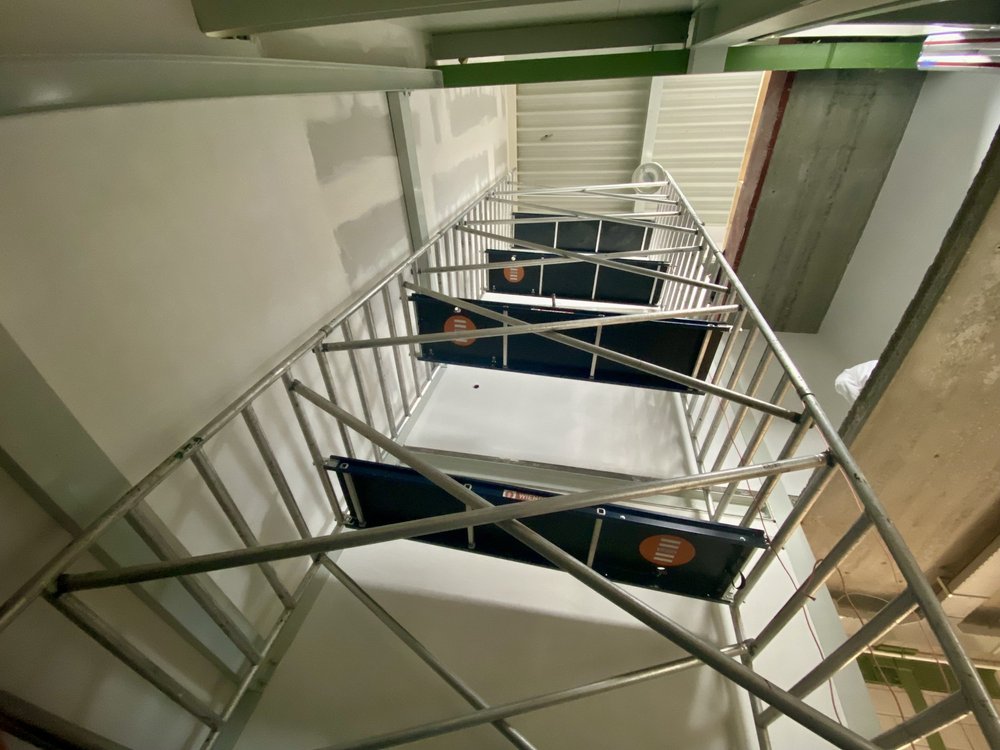 Steiger voor schilderwerk op hoogte in bedrijfsgebouw