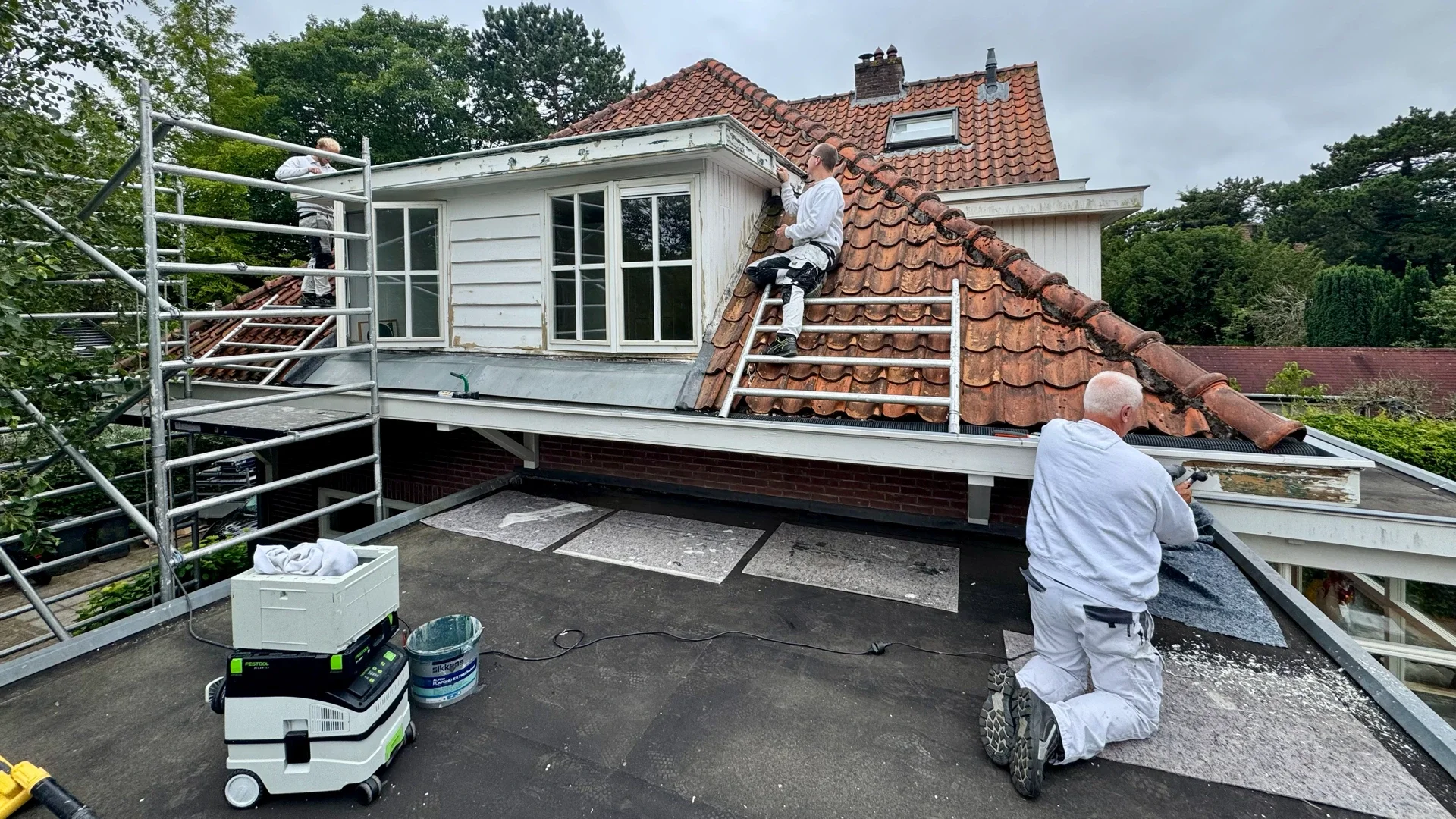 Schilders van Asseler tijdens schilderwerk aan een woning in Bentveld