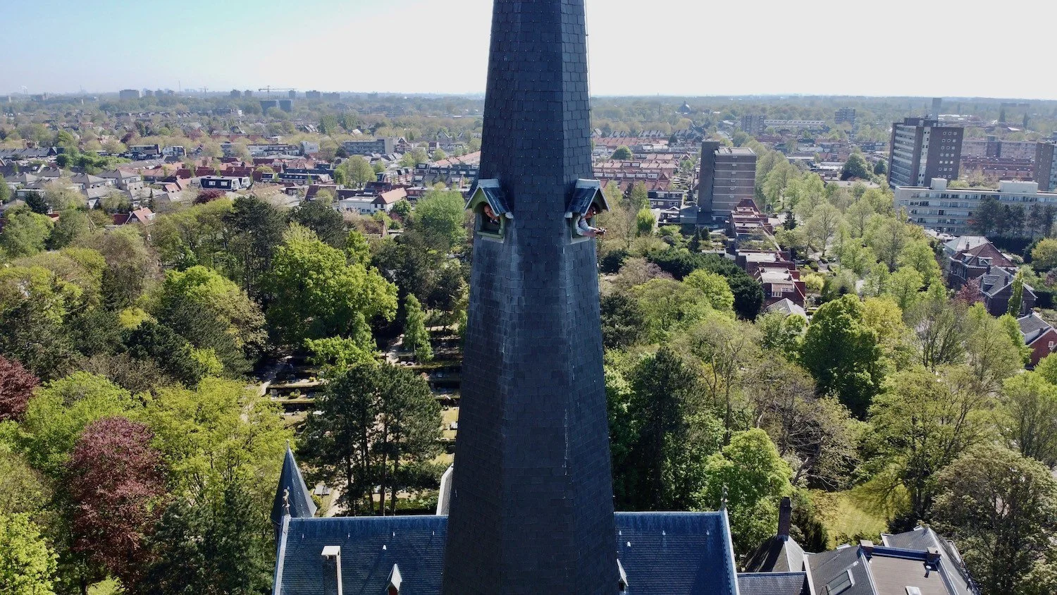 Dronebeeld van de Bavo Kerk en kerktoren in Heemstede tijdens het schilderproject