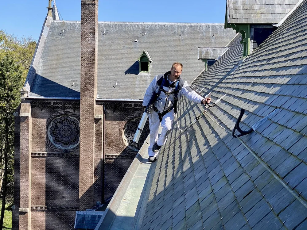 Mike Asseler tijdens schilderwerk aan de kerk in Heemstede