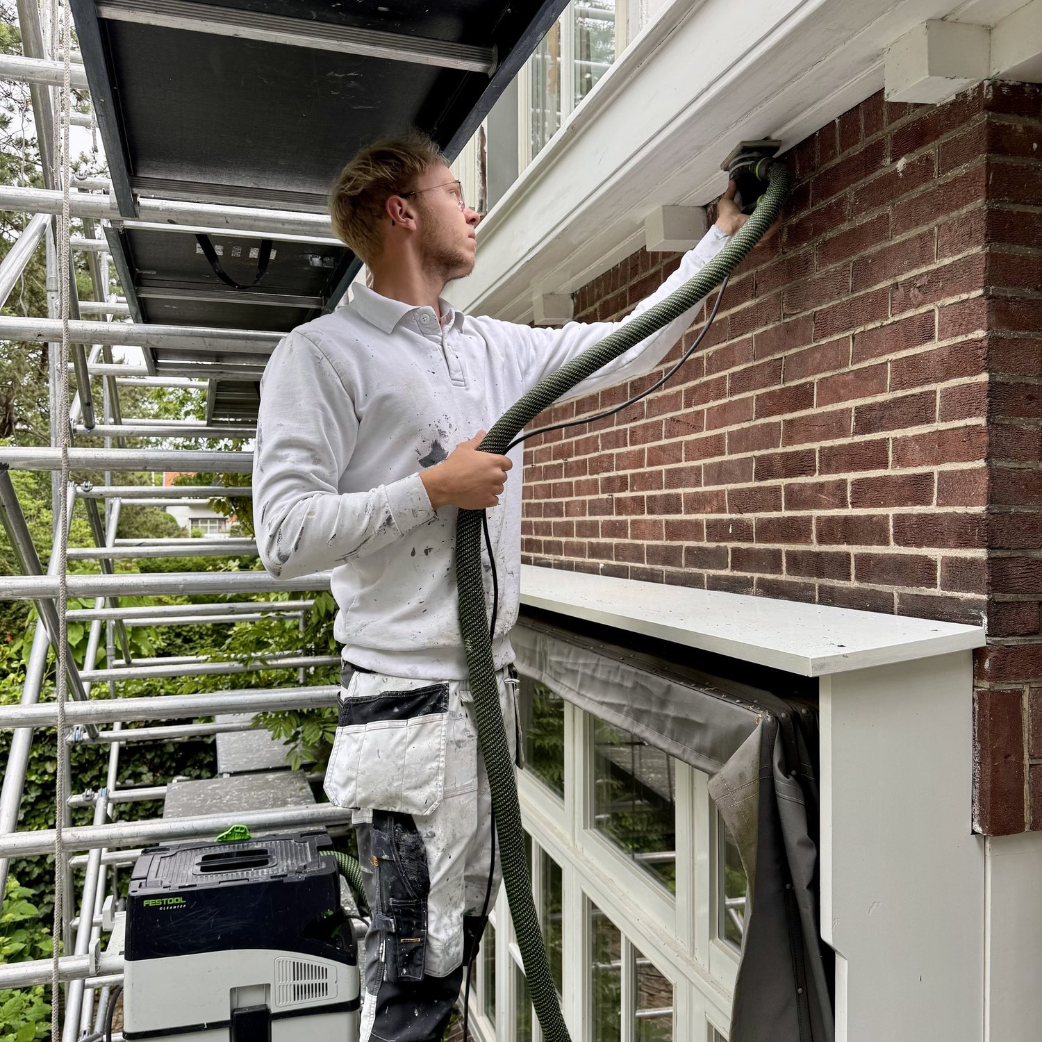 Barry Asseler tijdens het schuren en voorbereiden van buitenschilderwerk