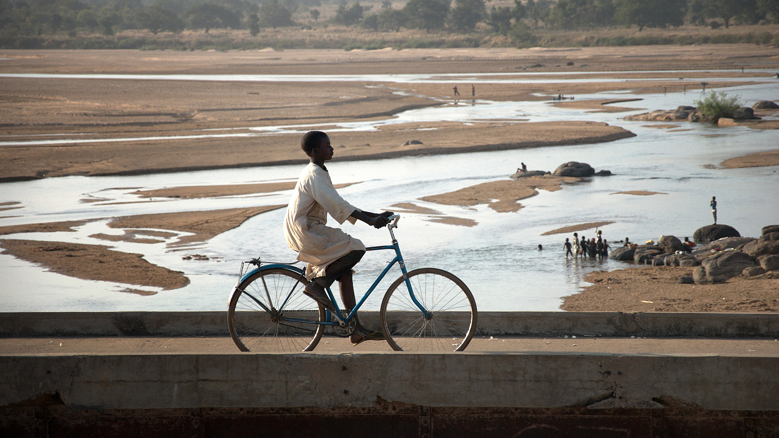His conviction to travel by his own strength, camp in unimaginable places and rely on intuition, leads him to exceptional adventures, but also to acutely experience fundamental issues. Besides night-time encounters with lions or hippos and repeated malaria and typhus infections, he struggles with water provision, discrimination and corrupted officials. He still faces the ultimate challenge – riding 3.000 kilometers through the Sahara against the relentless North Wind.