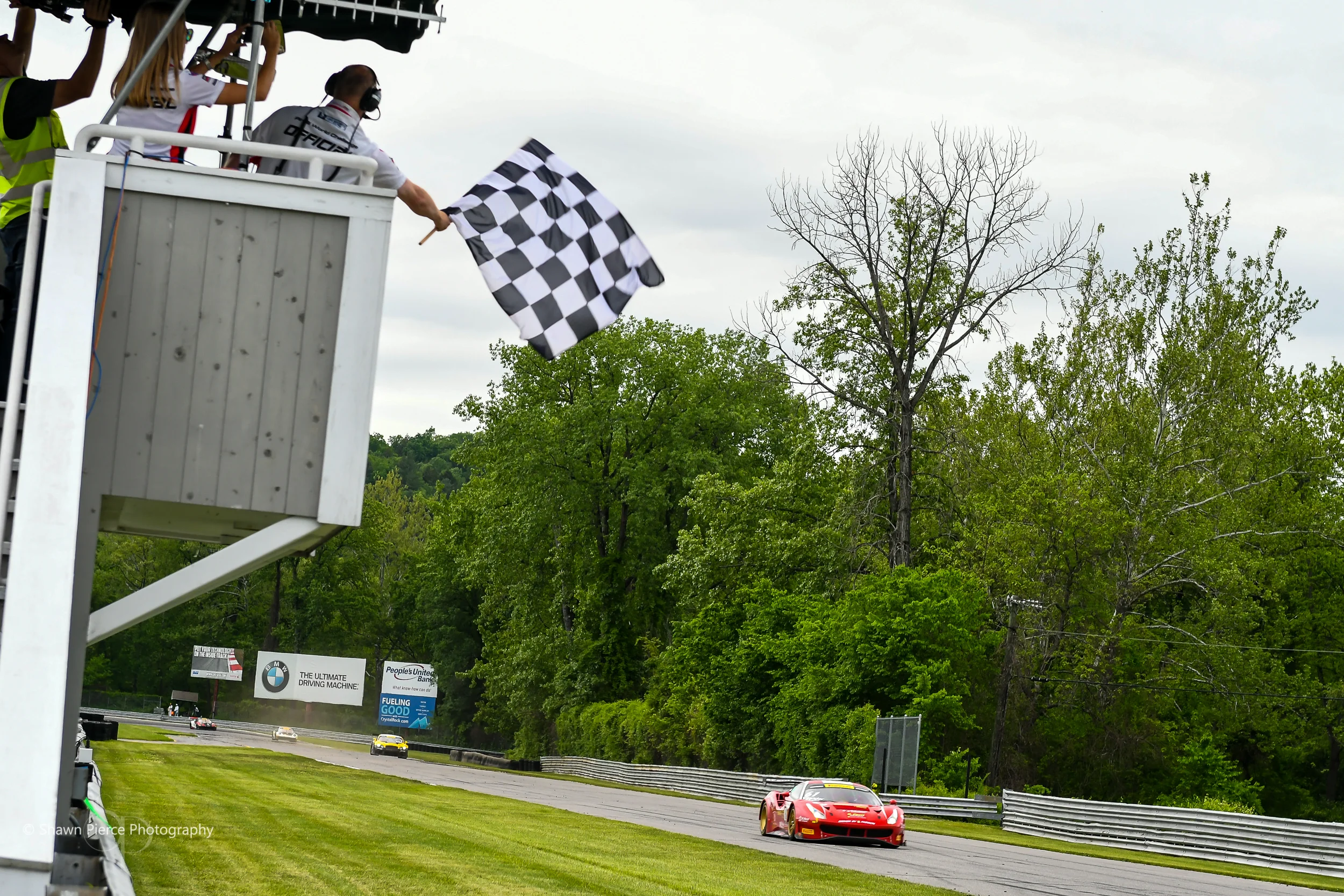 The #61 Ferrari crosses the finish line first to take the final checkered flag of the weekend.