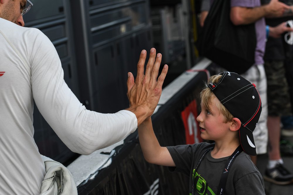  Corvette Racing’s Jordan Taylor high fives a young fan before the start of the Northeast Grand Prix.    