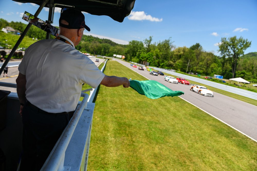 Rob Dyson waves the green flag while his son Chris leads the pack below. 