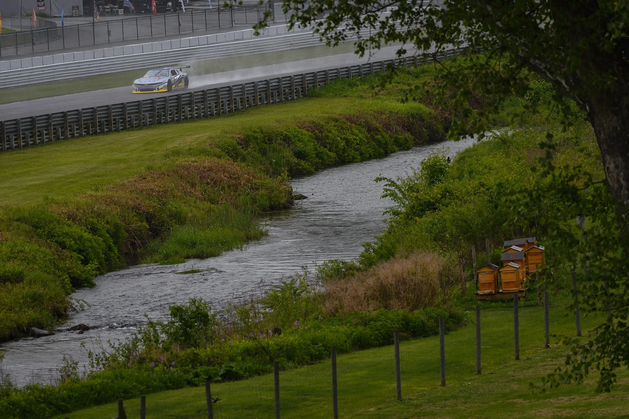  On Friday afternoon the rains came for the TA2 qualifying session. I decided to go out to the outfield hillside and managed to figure out how to capture the beehives, the creek, and the track in one photo.  