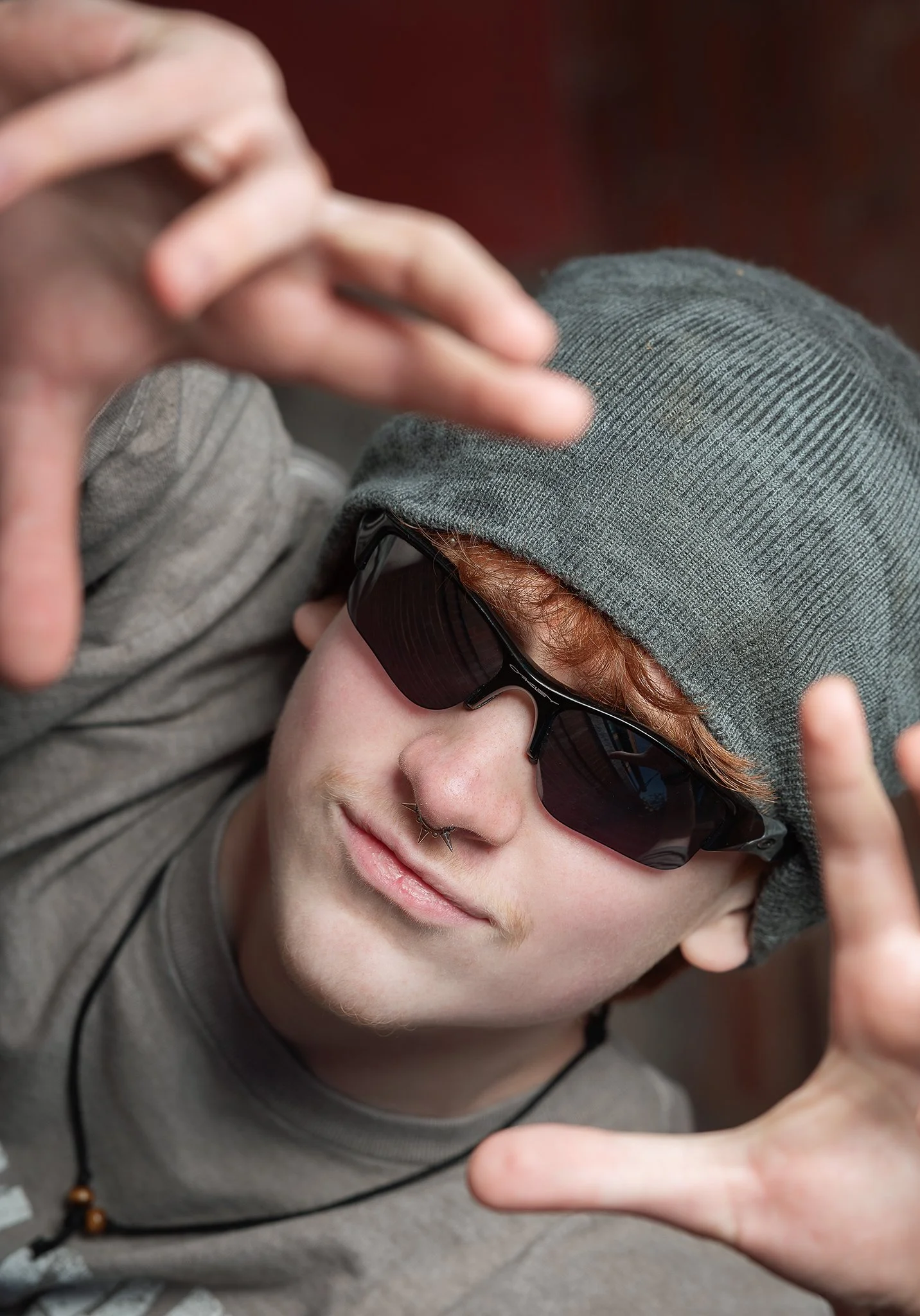 senior boy wearing sunglasses and a hat from a top down angle