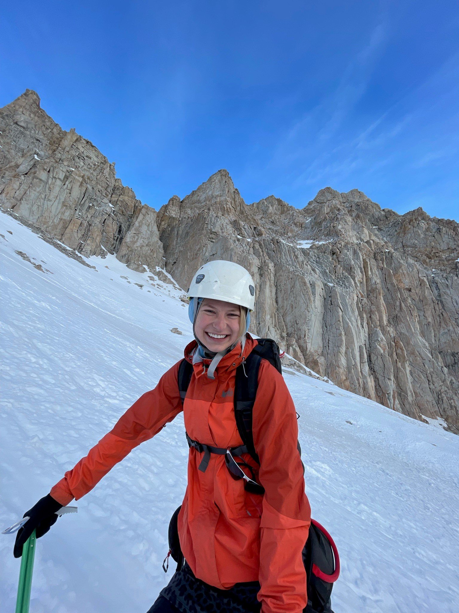 A woman smiling on a snowy mountain