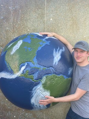Man hugging a large globe