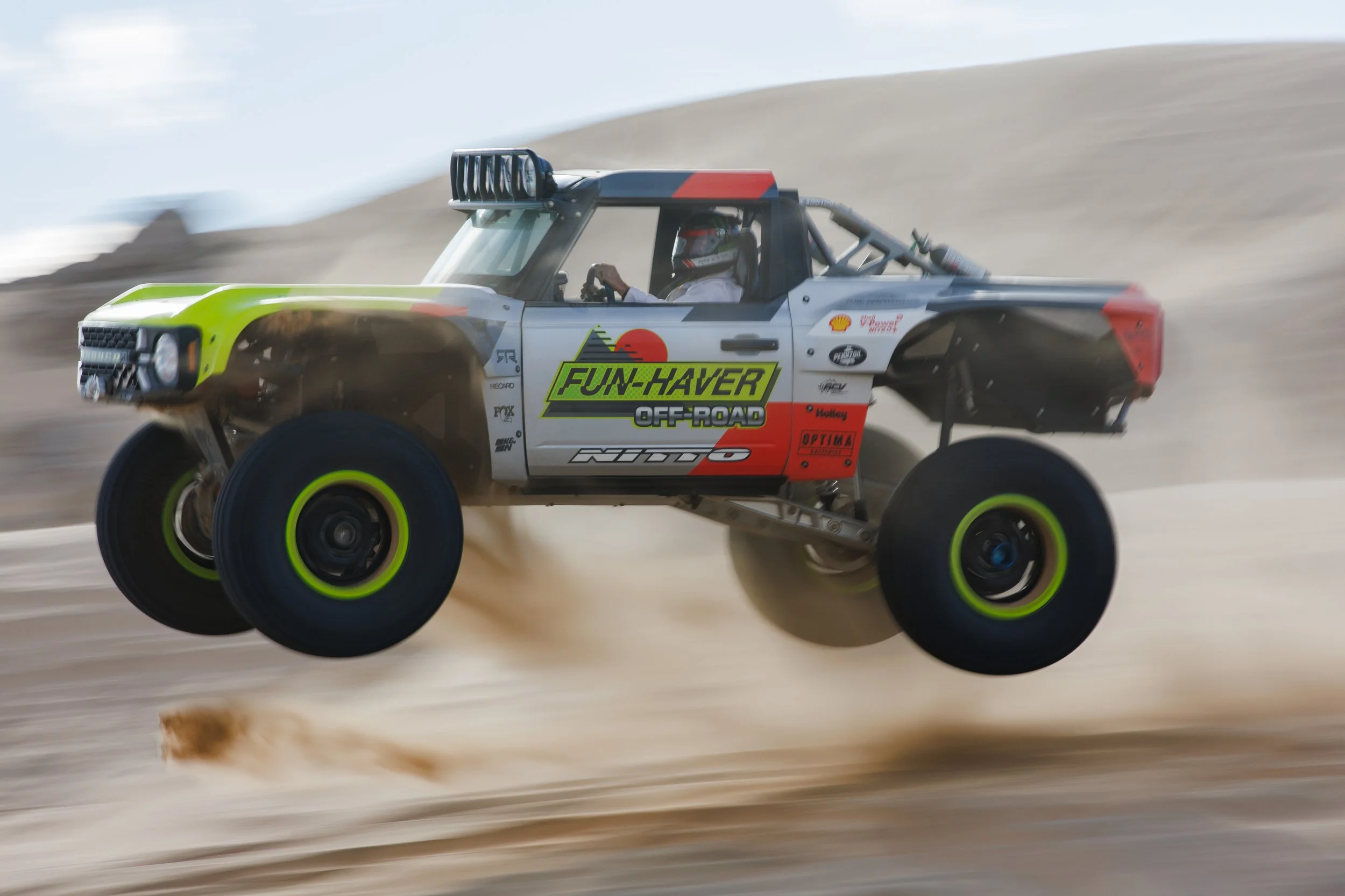 A Larry Chen photo of Vaughn Gittin Jr., author of the book "Ready To Rock," jumping the off-road truck El Bandito to promote RTR Vehicles racing at the Baja 500, Baja 1000, Mint 400 and King of the Hammers. Published by Carrara Media, 2026.