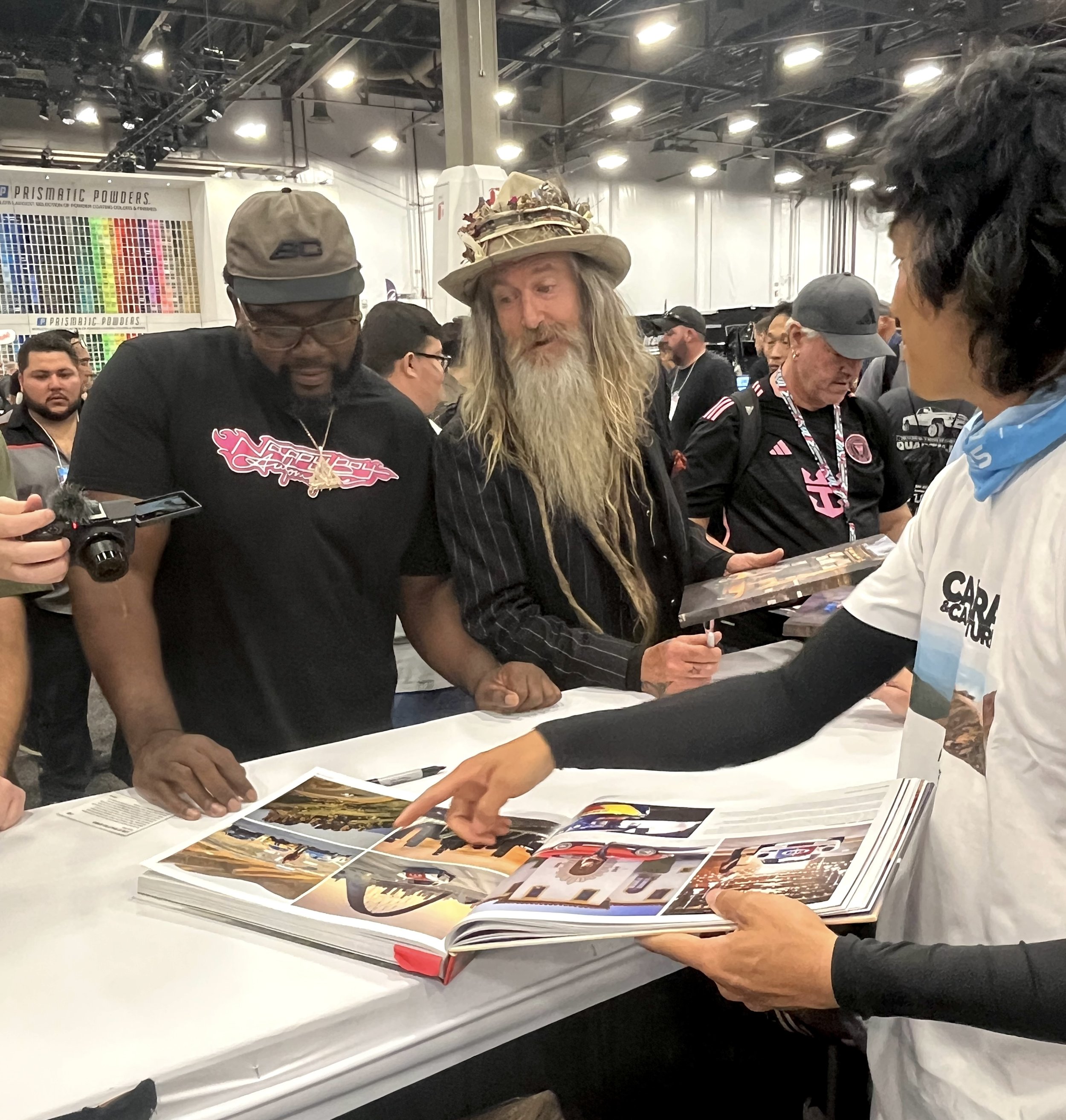 Hert, Magnus Walker and Larry Chen view 'Life At Shutter Speed' from Carrara Media at the SEMA Show 2025