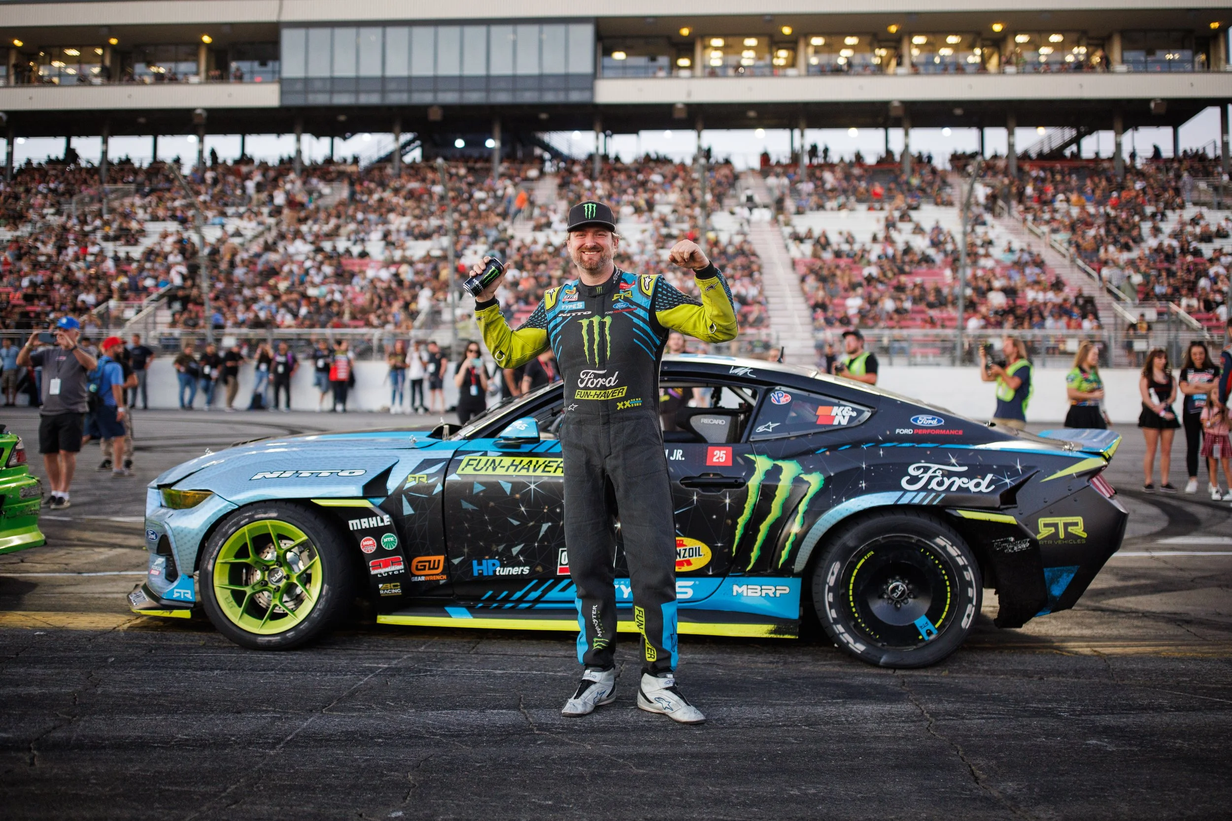 Vaughn Gittin Jr., author of the new book "Ready To Rock," flexes next to his Ford Mustang RTR Spec5-FD during a round of Formula Drift. Photo by Larry Chen. Published by Carrara Media, 2026.