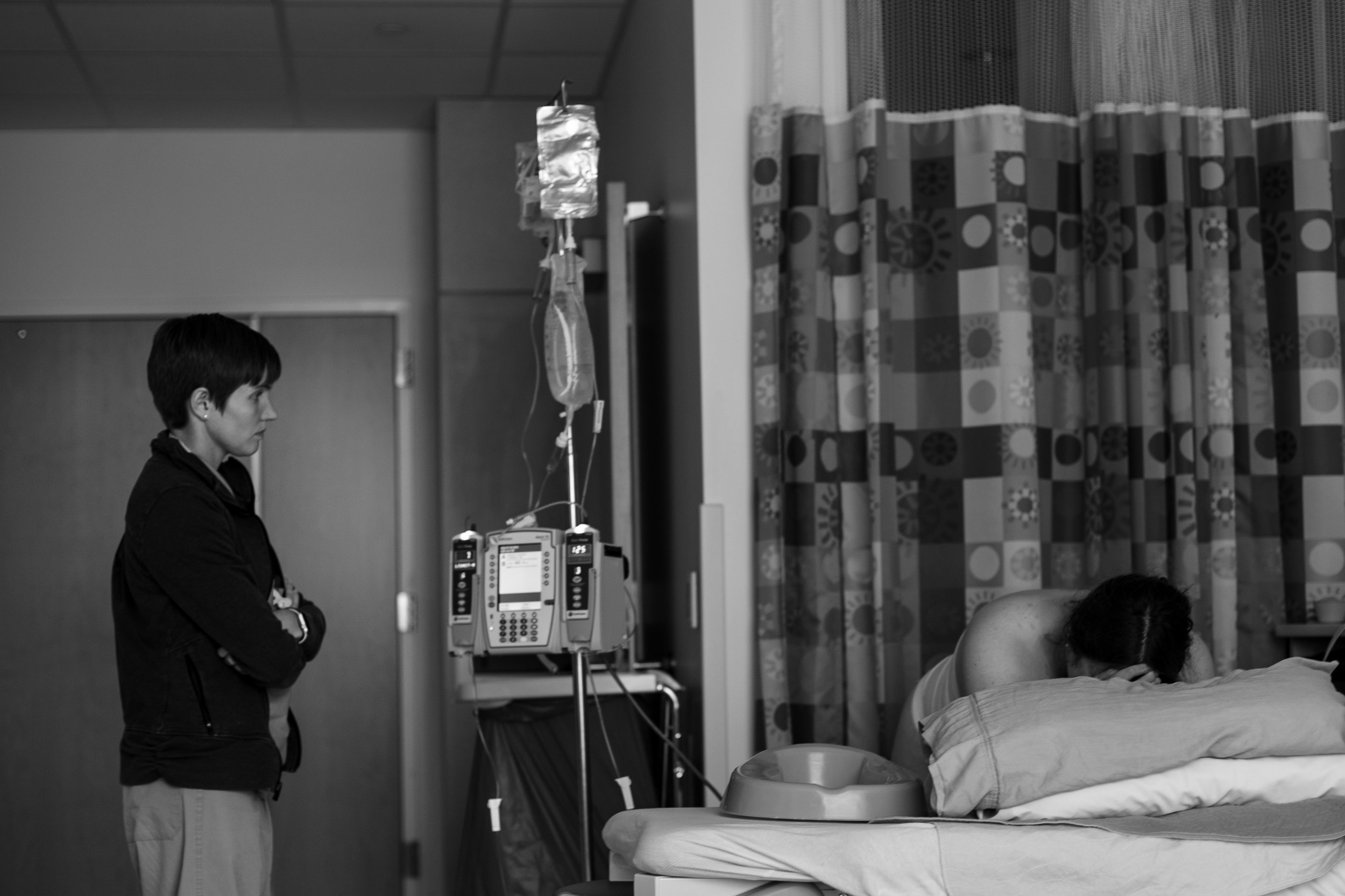 Midwife watches a woman labor in the hospital.