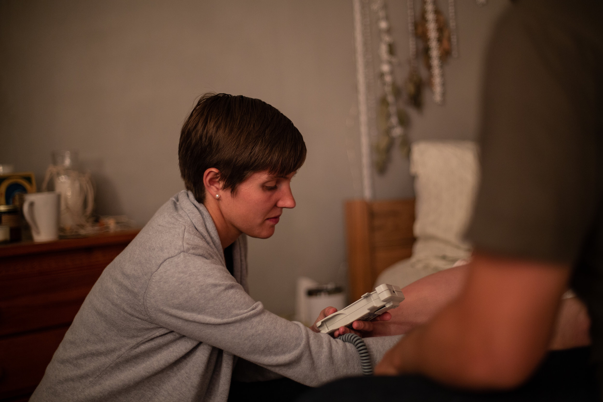 Home birth midwife Maura Winkler checking a baby's heart rate using a doppler.