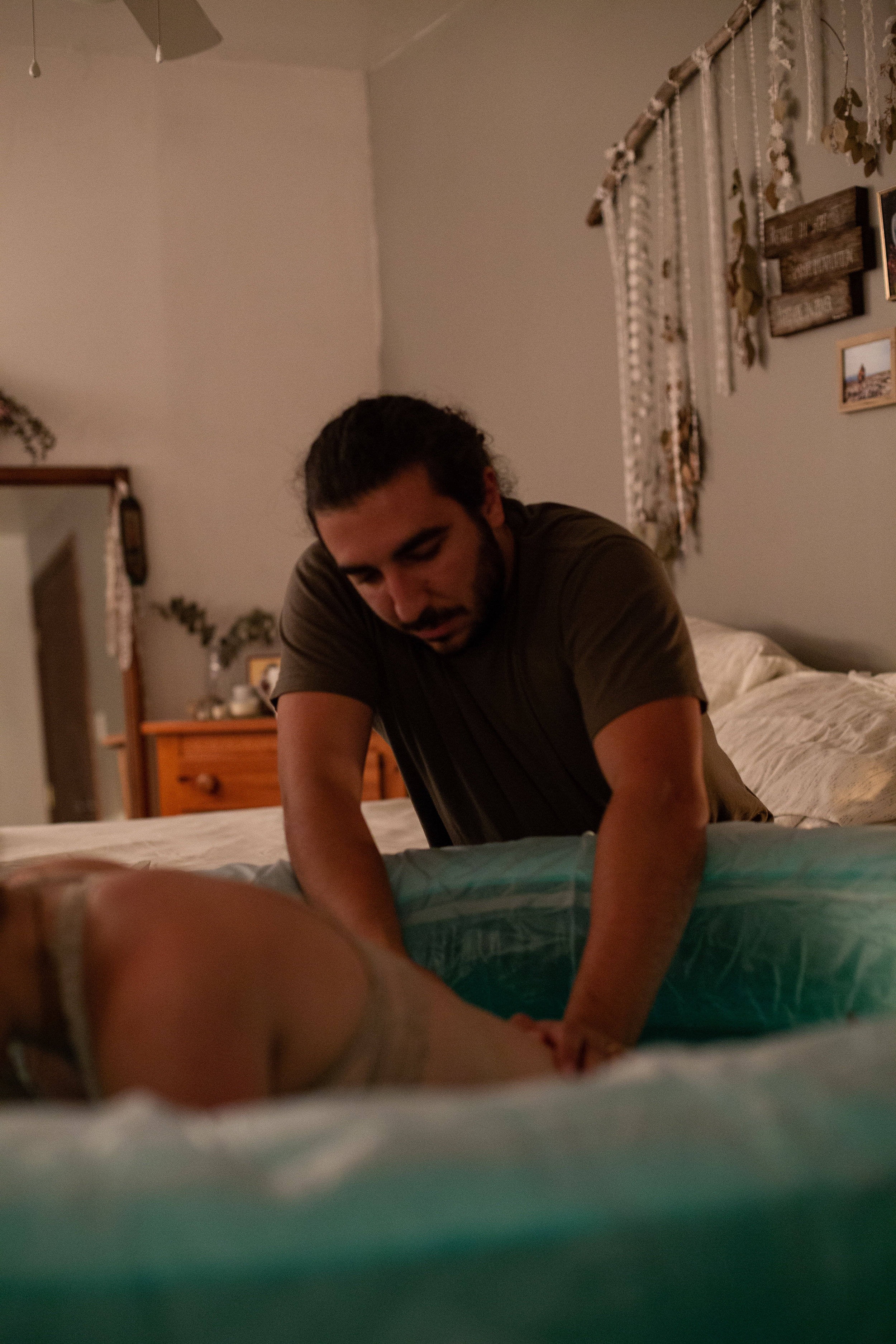 A man giving counter pressure to his wife during labor in their Buffalo home birth. 