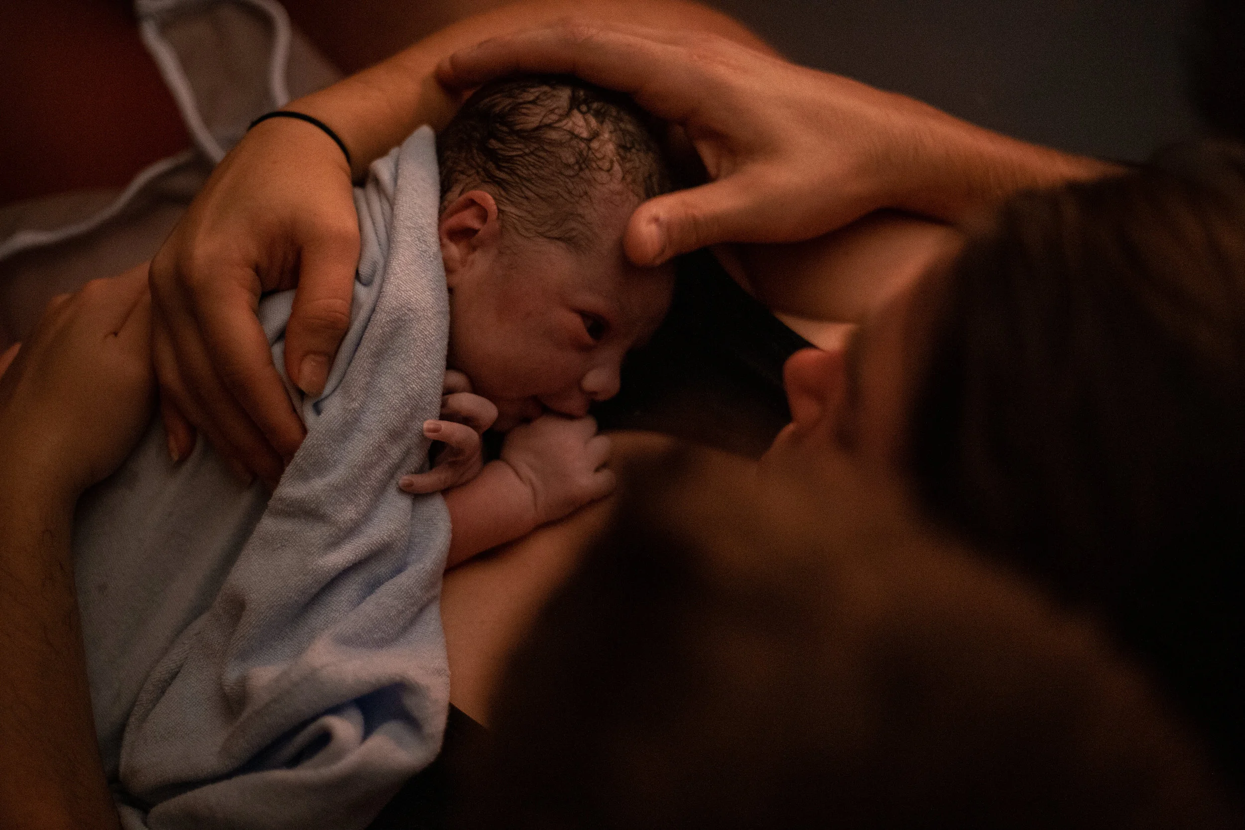 A picture of a newborn and his parents arms taken from above.