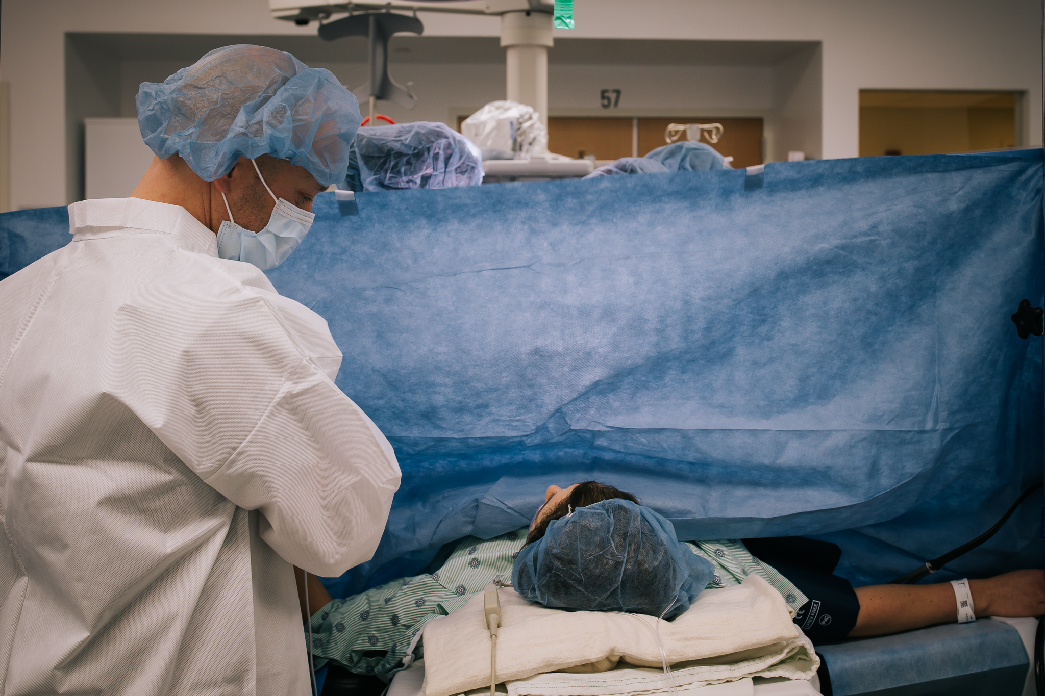 Blue surgery drape and woman laying on operating table. 