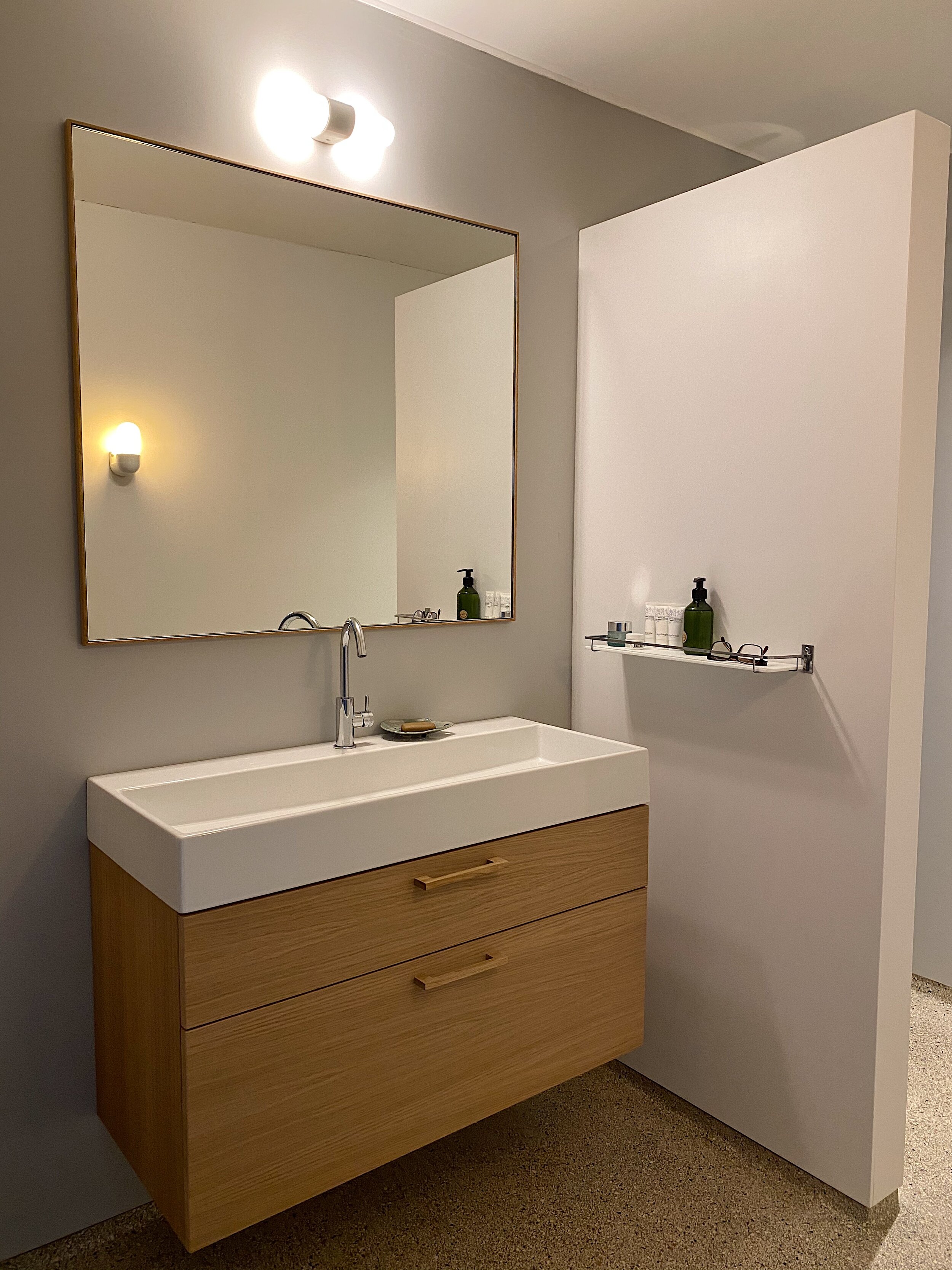 Ontwerp en realisatie van een compleet nieuwe badkamer. Een terrazzo vloer met opstaande plint, Corian douchewanden geven de ruimte een mooie uitstraling welke ook goed schoon te maken is. Het eiken meubel met de spiegel geven de ruimte wat sfeer