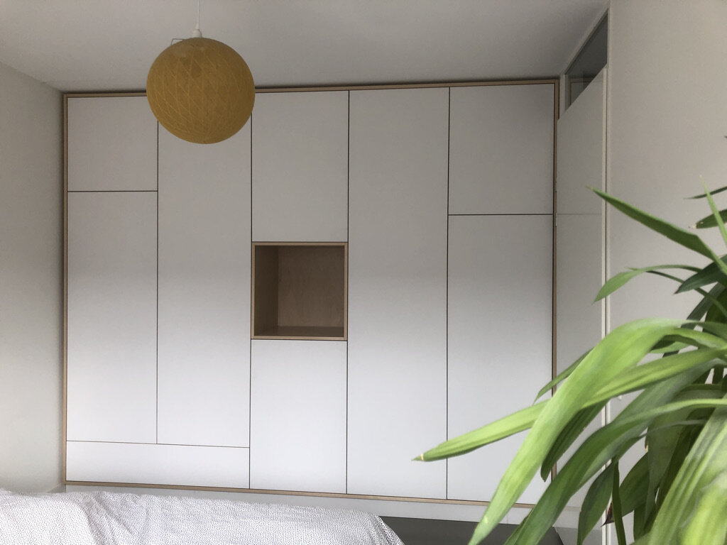 In een woonhuis in Amsterdam maakte we twee kastwanden, mat wit in combinatie met berken volumes.
