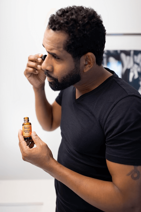 man grooming beard.png