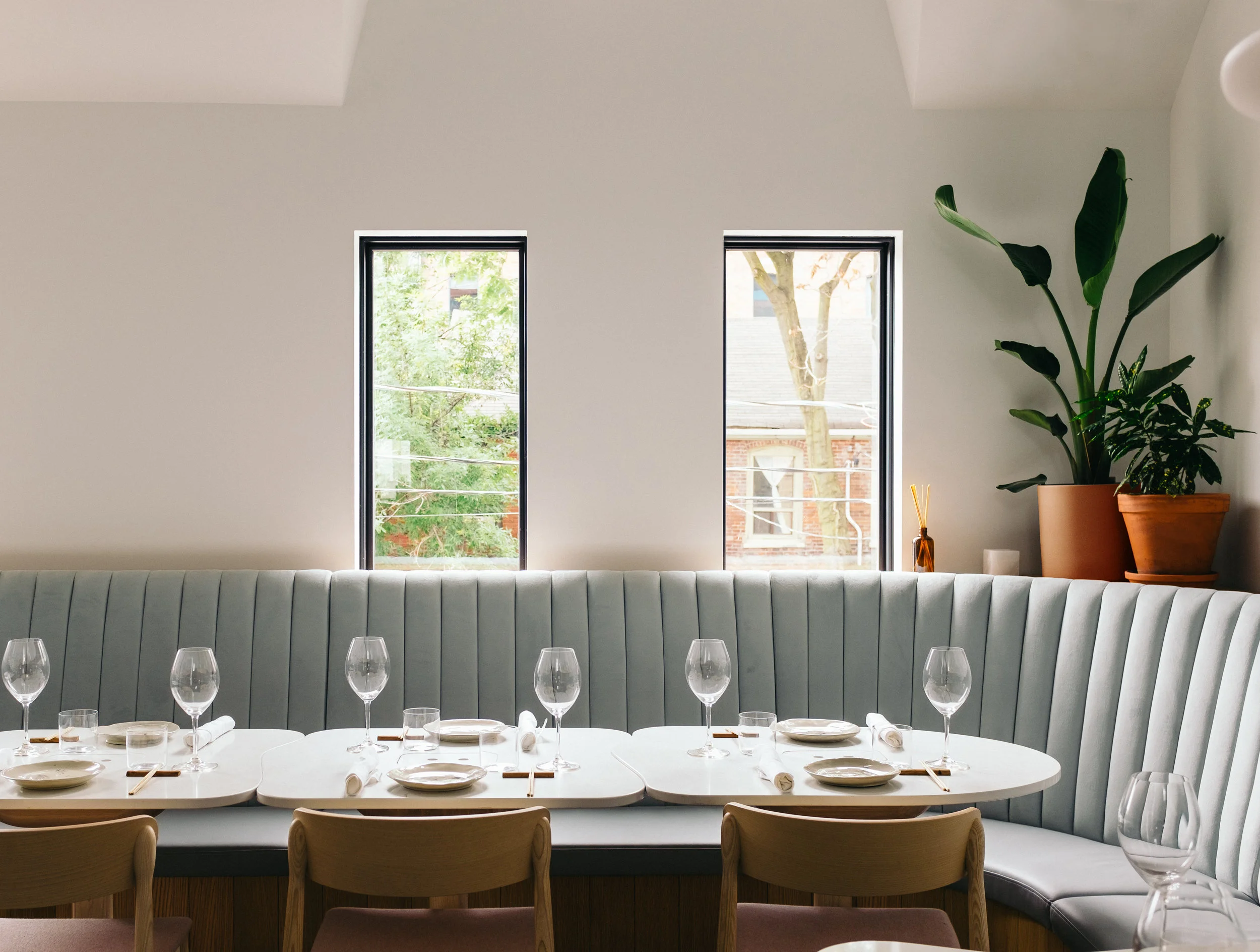 Corner of restaurant with rounded banquette seating and custom tables tucked into corner