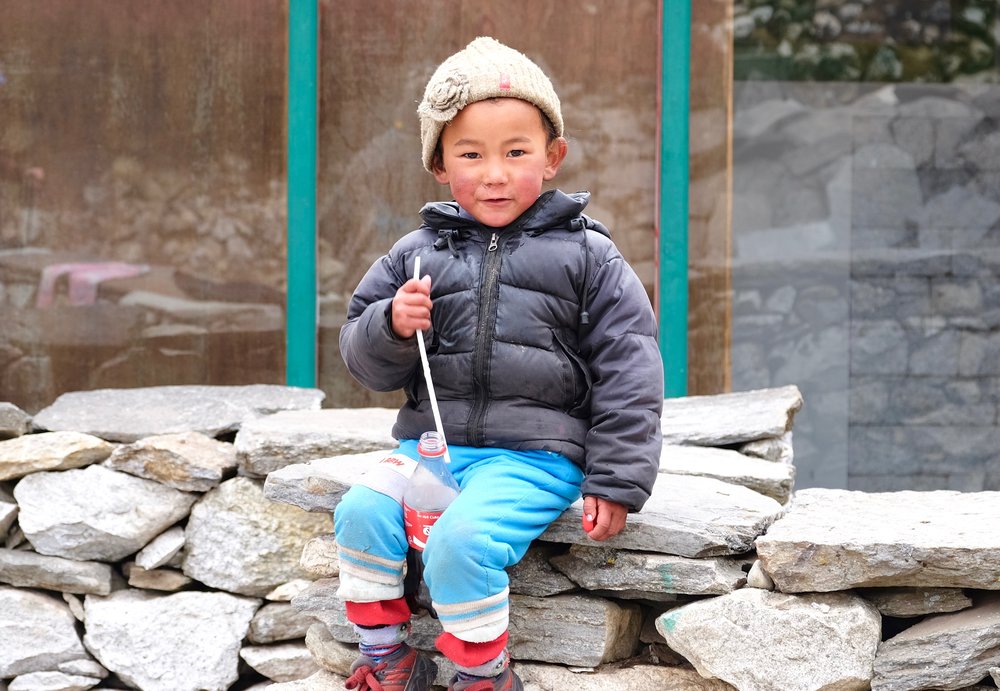 Sherpa child drinking a Coca-Cola