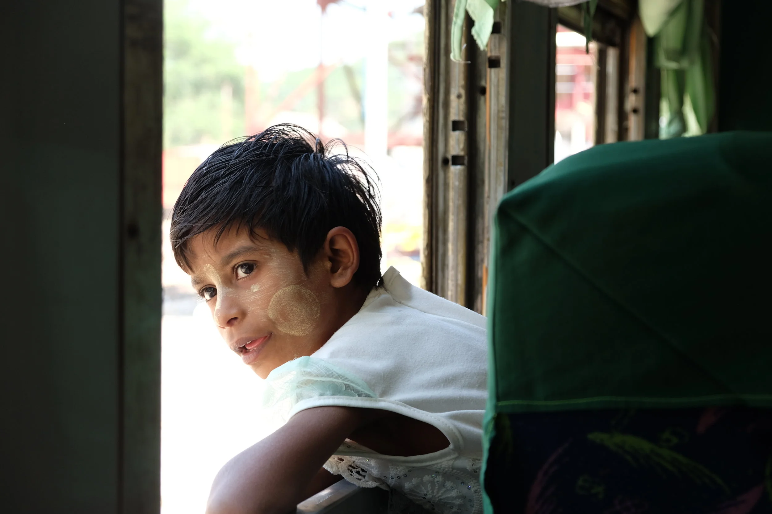 Child looks out the window of the train