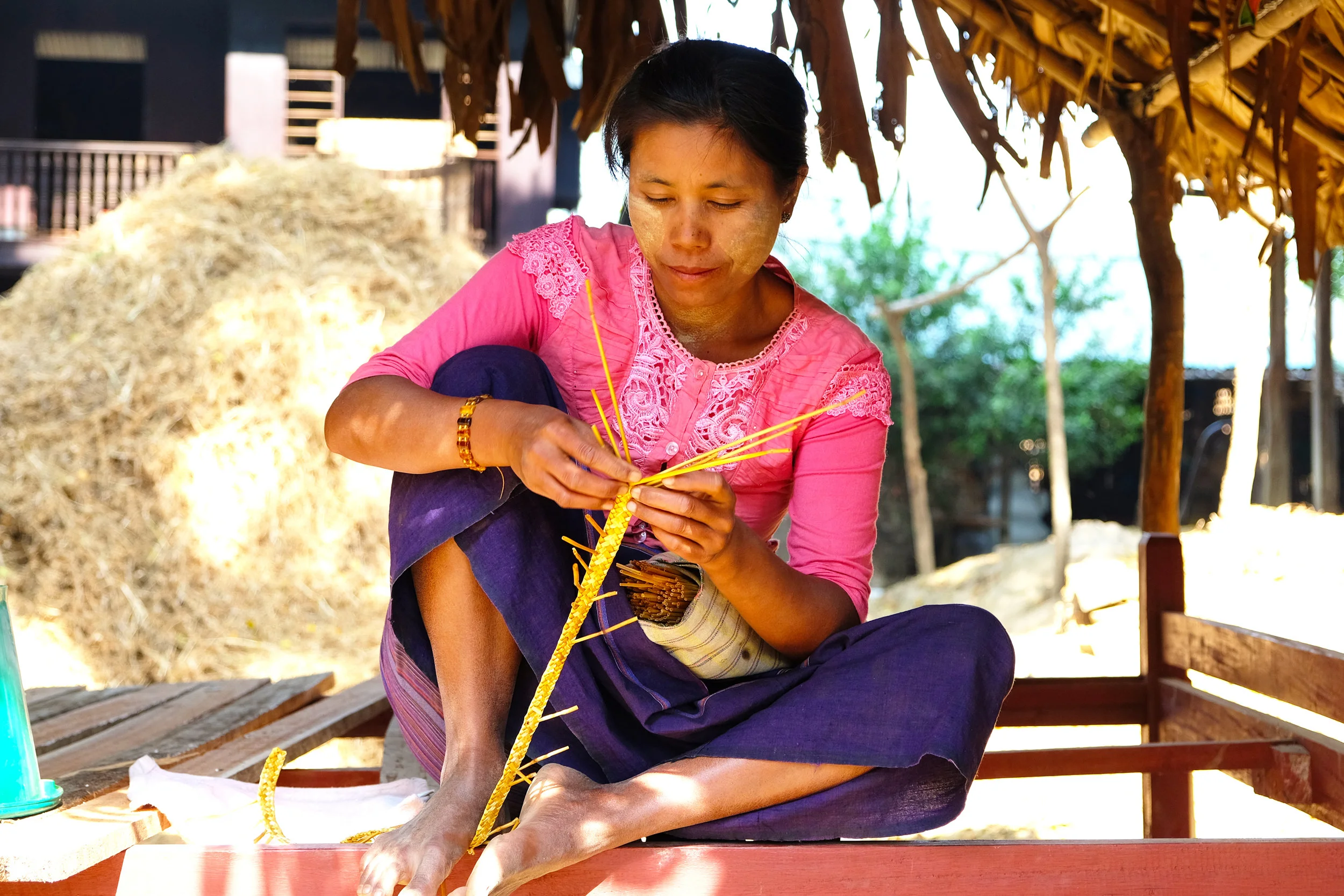 Woman weaving straw for a hat
