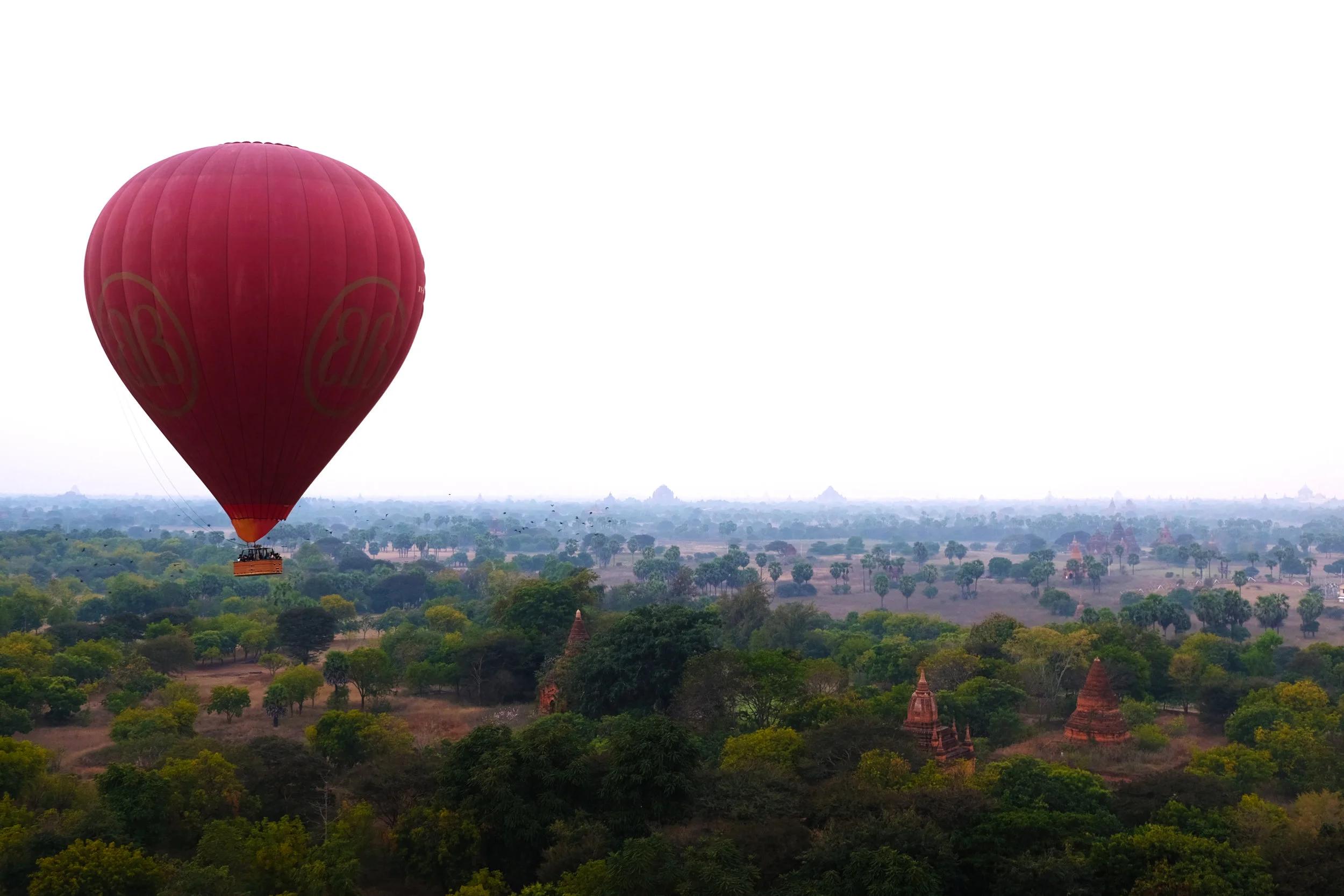 Hot air balloon passes over buddhist ruins, Bagan