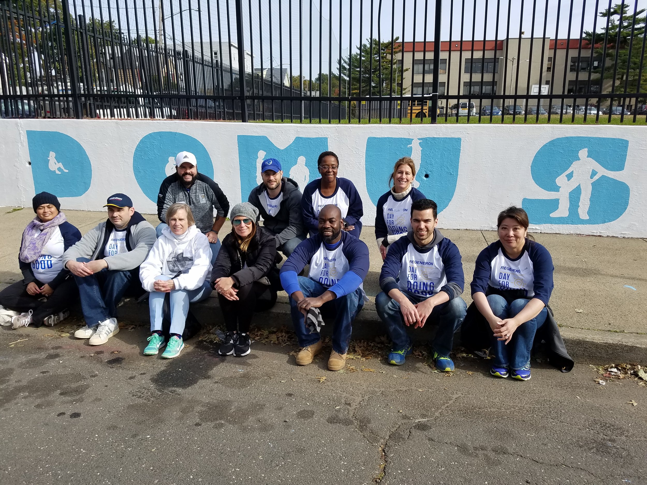 Talented Regeneron team posing for a picture after painting the new Domus logo.