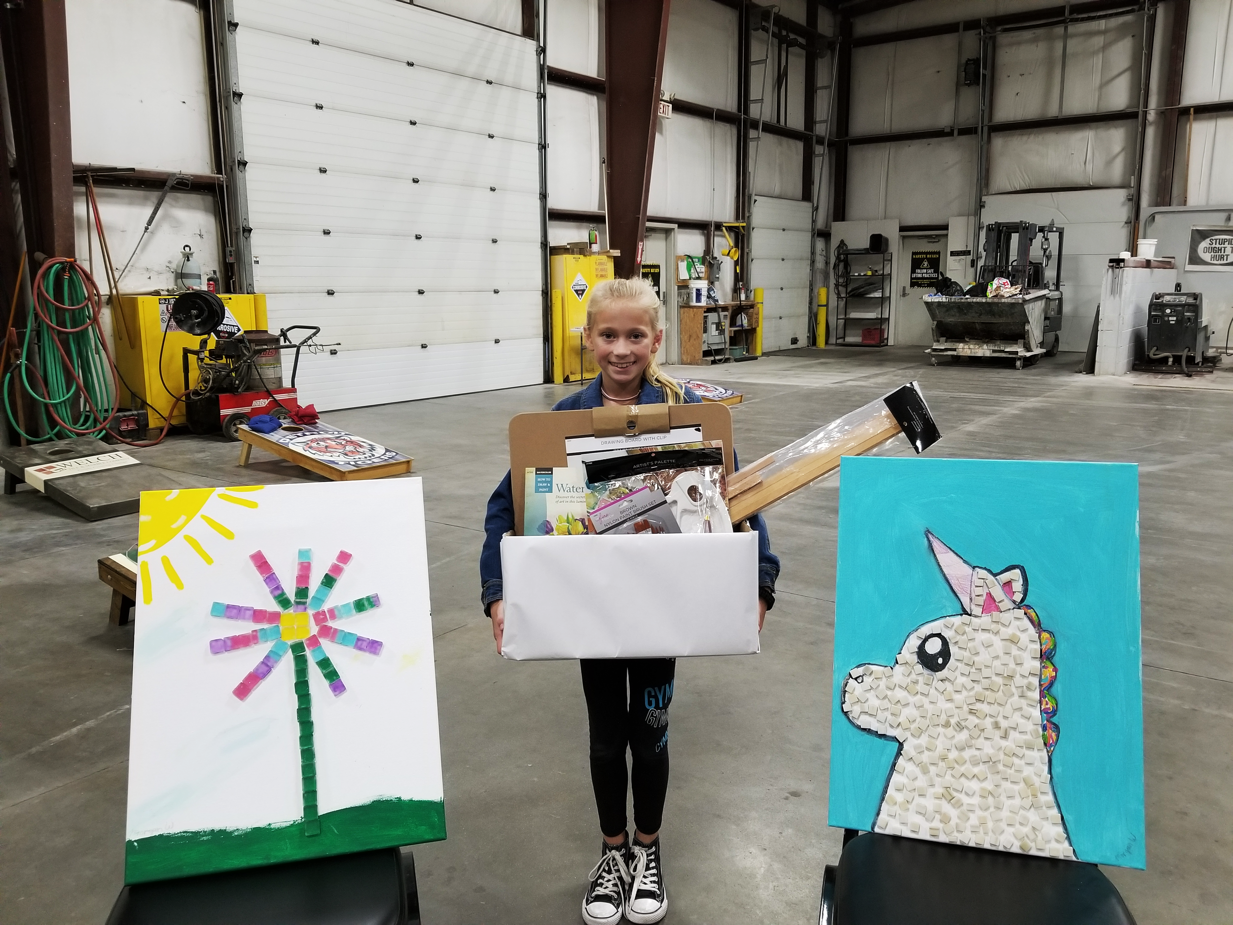 The winner of our art contest with her submissions and her prize