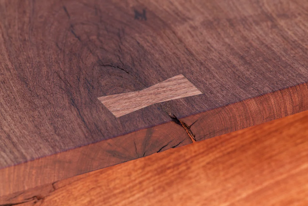   A butterfly stabilizes a split in the mesquite top
