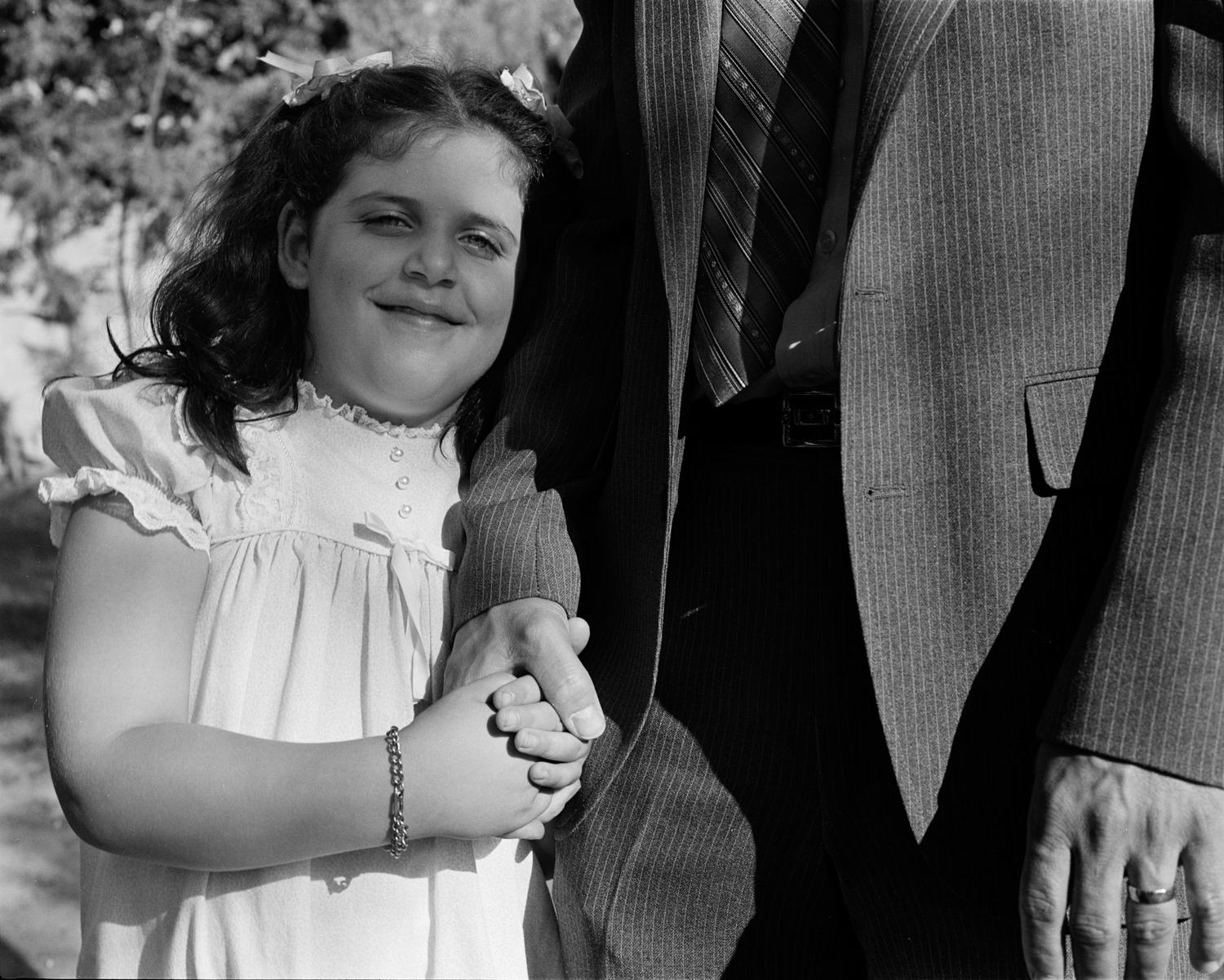 Girl holding her father’s hand, Los Angeles, CA, 1984