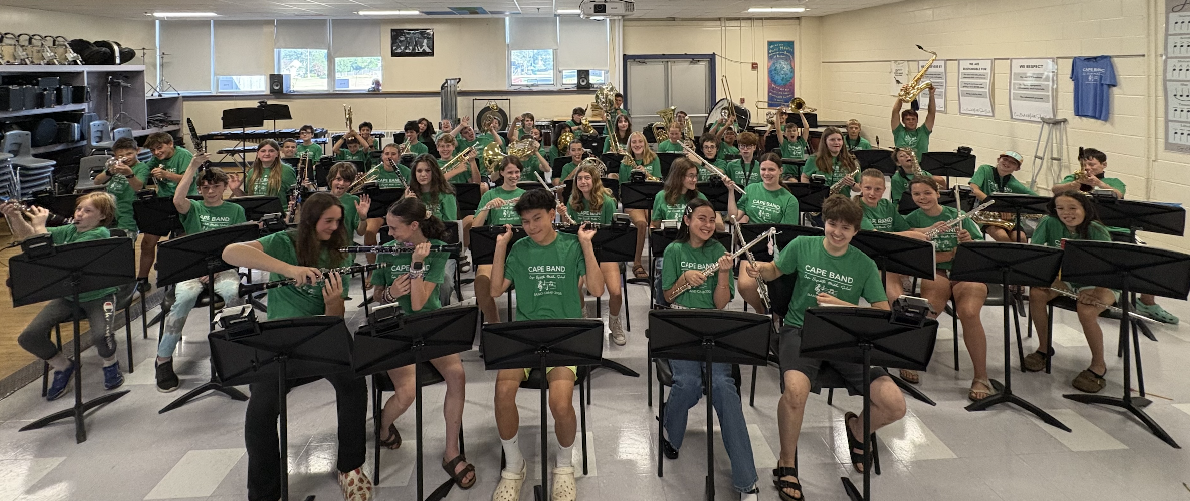 Cape Elizabeth band students hold up their instruments and smile