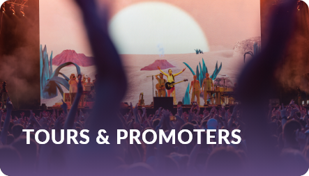 Tours and promoters: band performing on a large stage with projected visuals above a silhouetted crowd