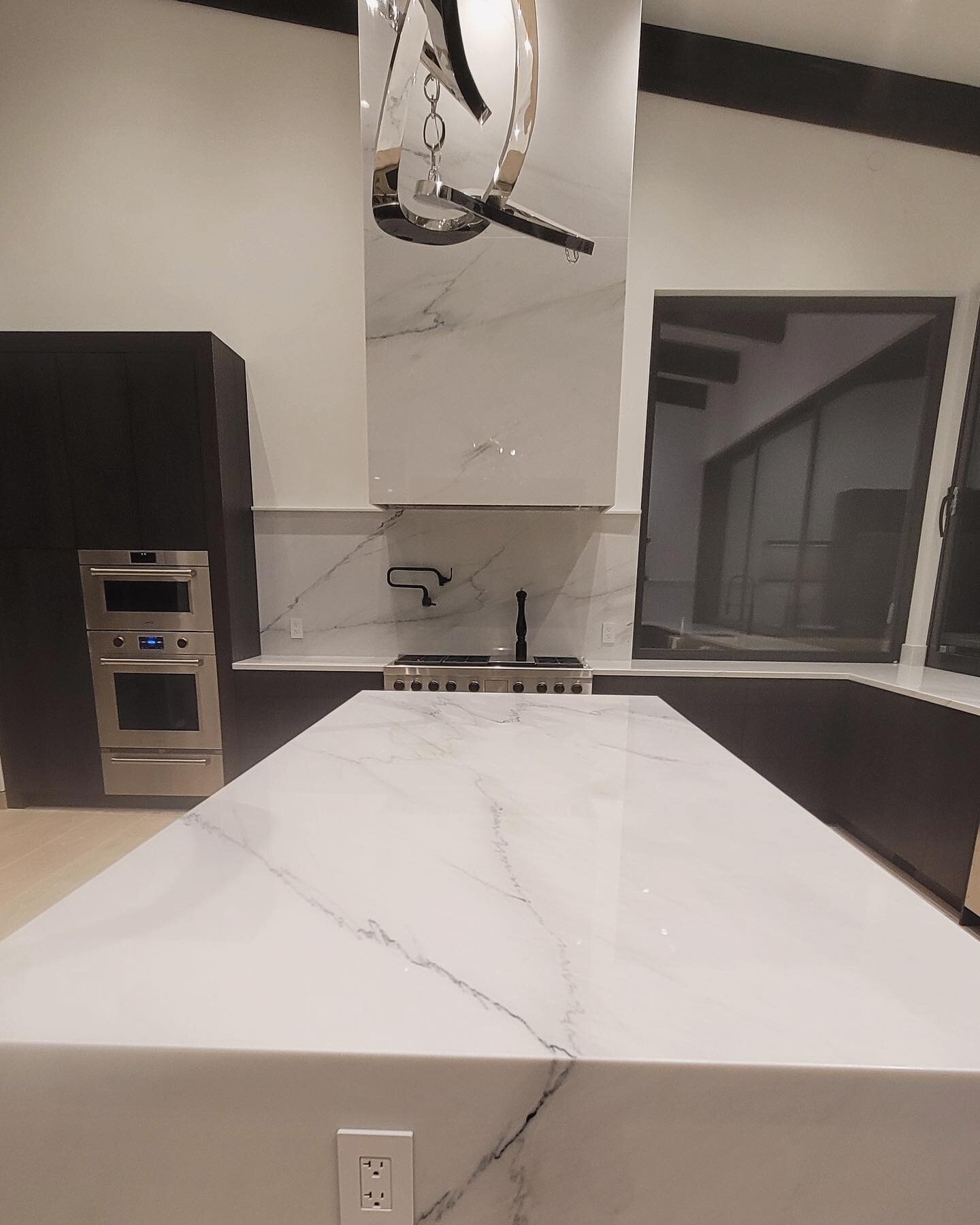 Calacatta Lincoln Marble sourced @haristones; this one of kind kitchen features the cladded hood vent that goes up 11&rsquo; feet in the air! Designed by @blue_alice_space_design 
.
.
.
.
.
.
#revitastone #revitastonecountertopskelowna #kelownabuilde