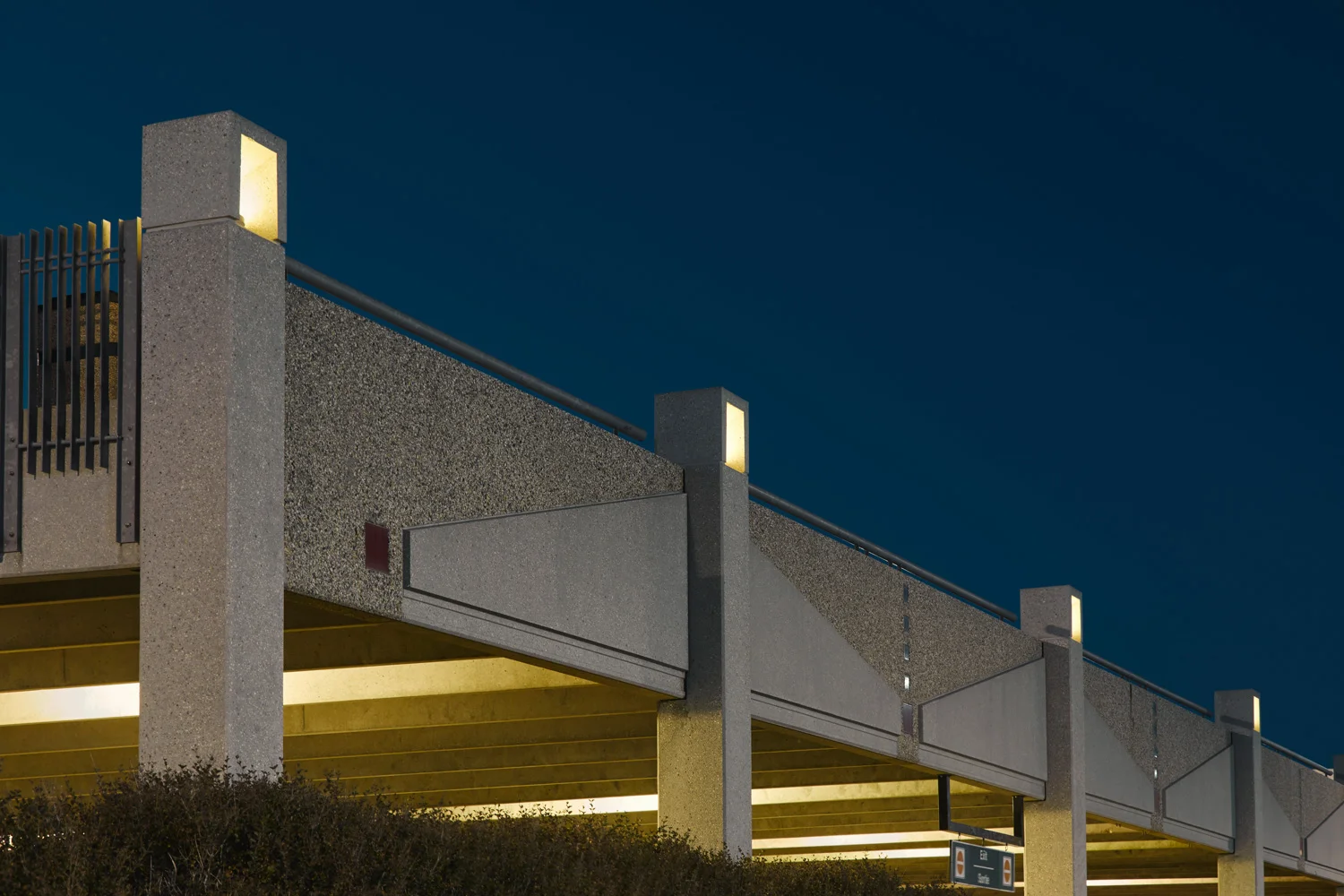 ….Wall panels of the precast concrete parking structure were developed with custom patterning in ceramic tile and coloured concrete to reflect the logo of the Winnipeg Airports Authority. The perimeter concrete lanterns, like classic Japanese stone lanterns, provide atmospheric lighting, complementing the character of the building. ..Les panneaux muraux de la structure en béton préfabriqué du stationnement furent conçus selon un motif original de tuiles de céramique et de béton coloré, reflétant le logo de la Winnipeg Airports Authority. Les lanternes de béton ornant le périmètre de la structure, rappelant les lanternes de pierre japonaises, procurent un éclairage d'ambiance et ajoutent du caractère au bâtiment. ….