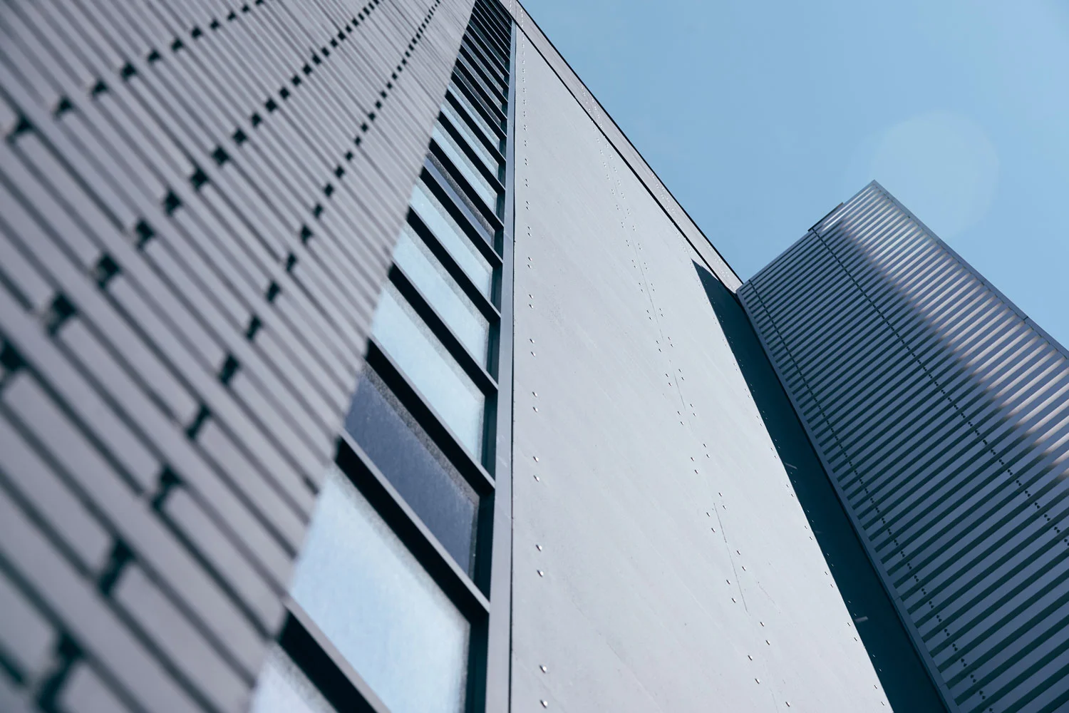 ….Artful aluminum fins punctuate the ends of the building and identify the main entrance. ..Des ailerons en aluminium marquent les extrémités du bâtiment et identifient l’entrée principale. ….
