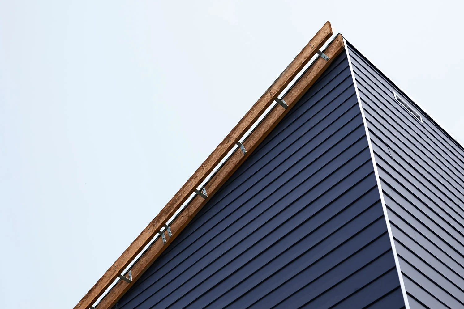 ….A decorative wooden fascia covers a downspout that takes water away from entries. ..Un fascia décoratif en bois recouvre une descente d’eaux pluviales servant à éliminer le surplus d’eau des entrées. ….