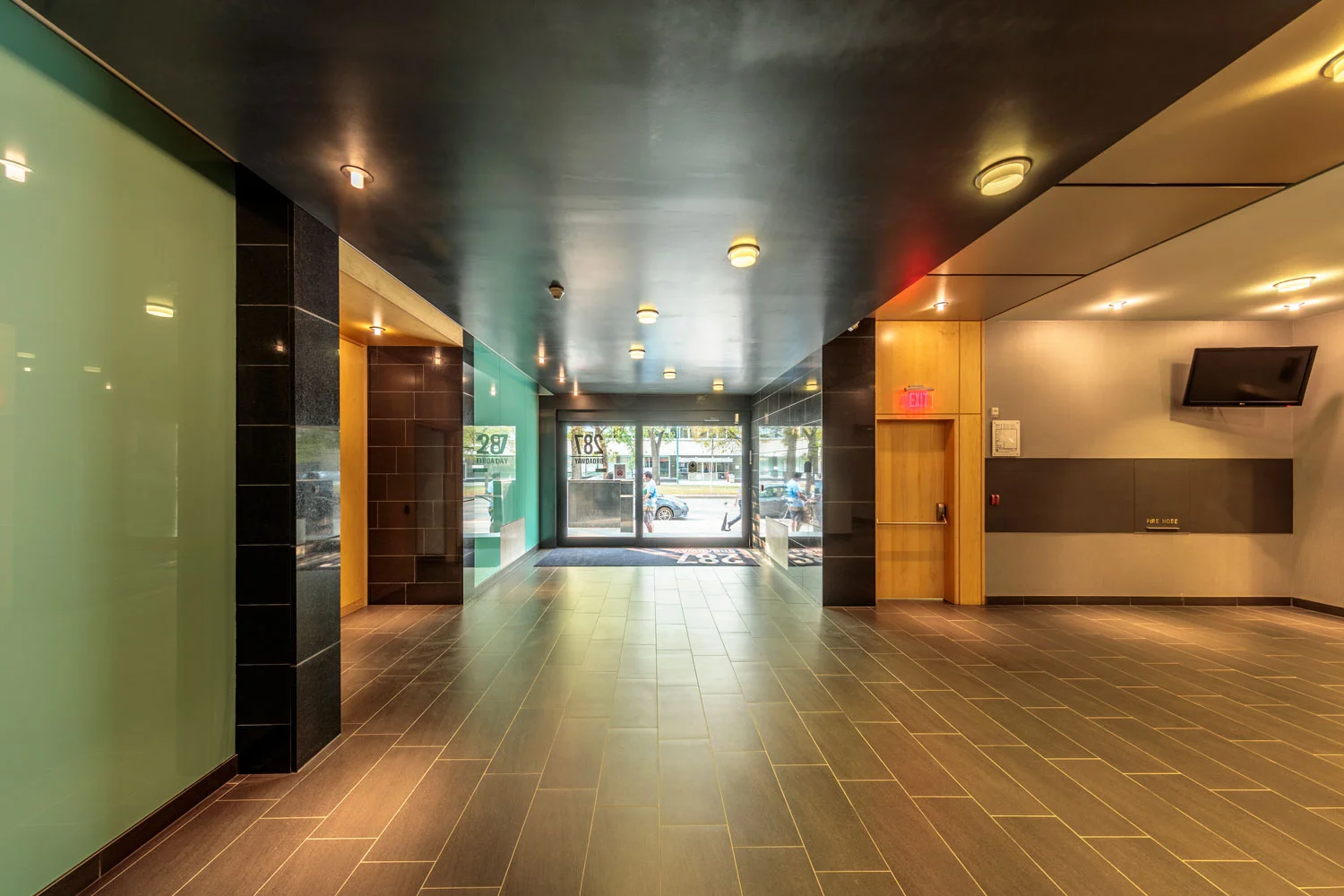 ….Black granite is used for wall tiles and flooring, which harmonizes with the tiles used on the exterior façade. The entry’s high-gloss ceiling visually guides visitors to the elevator. ..Les murs et planchers sont couverts de granite noir, s’harmonisant avec les tuiles de la façade extérieure. La haute brillance du plafond de l’entrée sert de guide visuel pour se diriger vers l’ascenseur. ….
