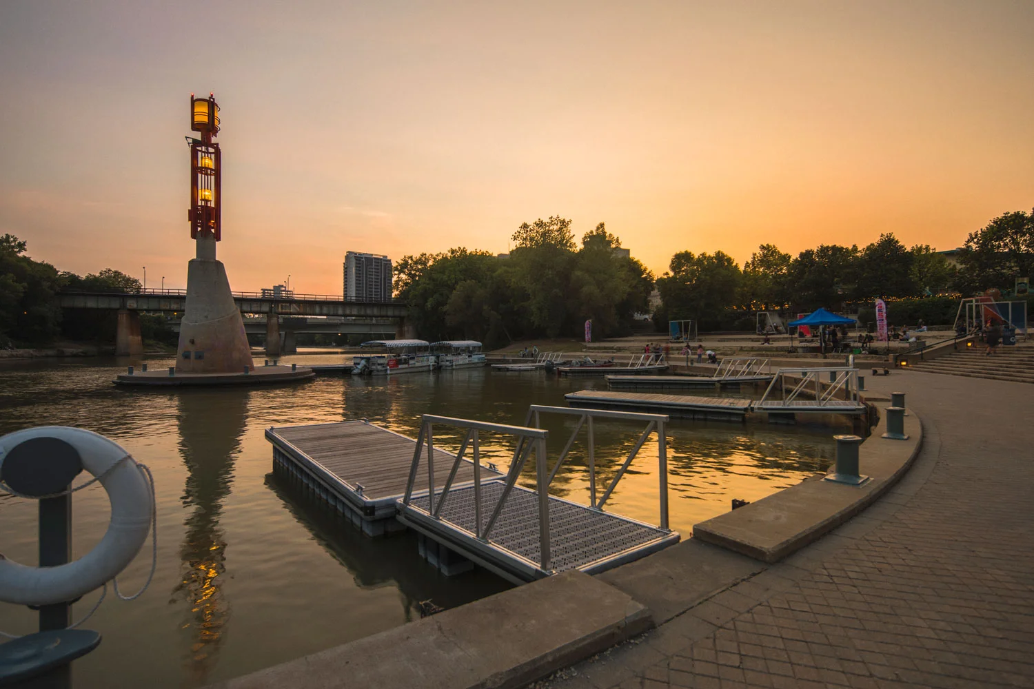 ….In 1987 the muddy banks of the Assiniboine River were inaccessible. Stabilizing the banks required extensive geotechnical and structural engineering as well as in-depth coordination with waterways and fisheries regulators. The waterfront is now a lively harbour in summer and the focus of winter activities. ..En 1987, les rives boueuses de la rivière Assiniboine étaient inaccessibles. Des efforts d'ingénierie en géotechnique et en structure furent requis afin de stabiliser la rive, sans compter la coordination complexe avec les autorités régulant la pêche et les cours d’eau. Le bord de rivière est maintenant animé tout l’été, en plus d’être le centre des activités hivernales. ….