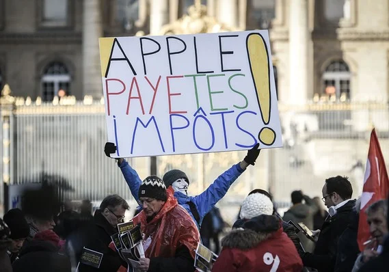 STEPHANE DE SAKUTIN/AFP/Getty Images French activist Jean-Baptiste Redde holds a placard reading "Apple pay your taxes" at a protest in Paris in February 2018
