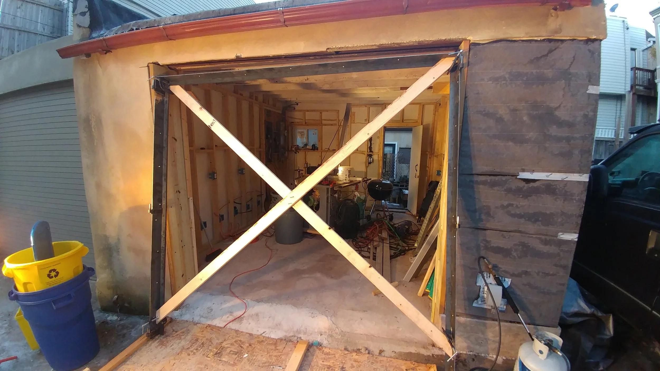 Installing the doors large, steel frame. On this frame are the hinge pins. Once this frame was shimmed square and plumb, the doors were installed, shimmed and finally attached to the hinges.