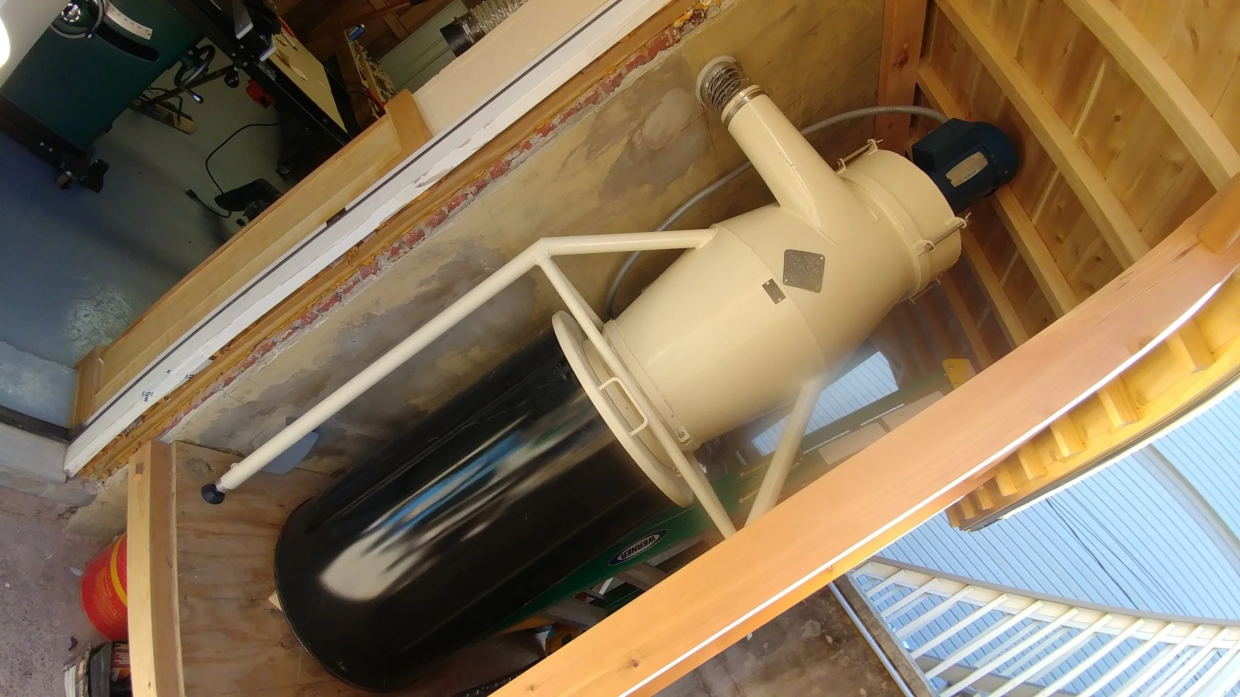 Hidden behind the wall is a cyclone dust collector, a 30-gallon air compressor, and various garden tools.