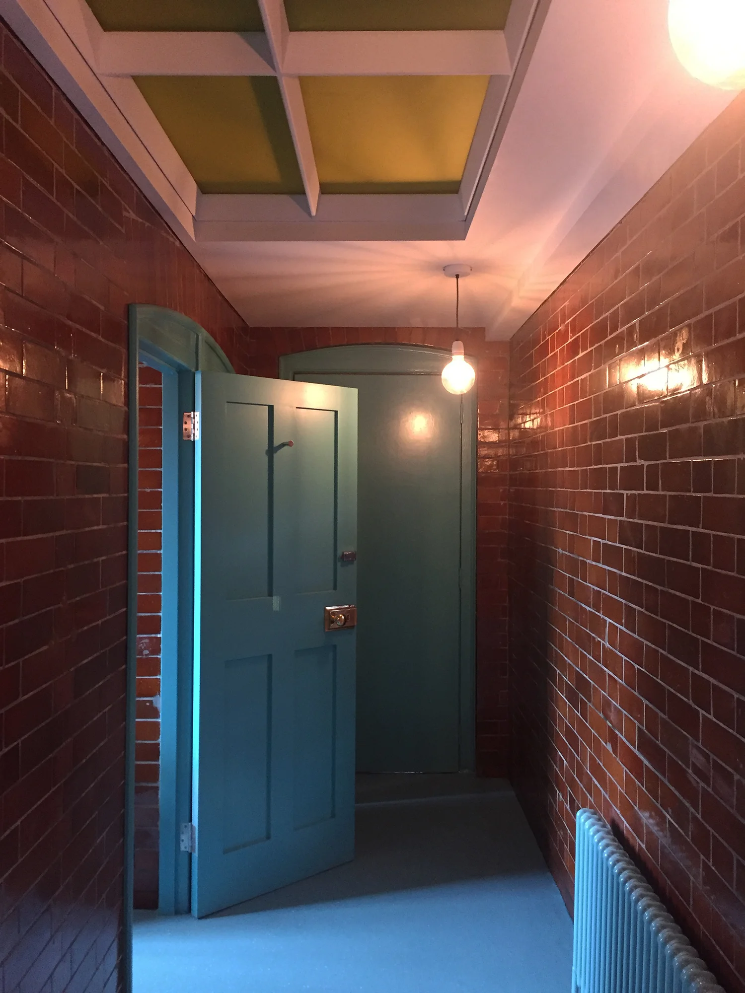 Refurbished lavatories: the original tiles have been restored and a turquoise blue paint and floor chosen to create a contrast in colour and texture that reveals their quality.
