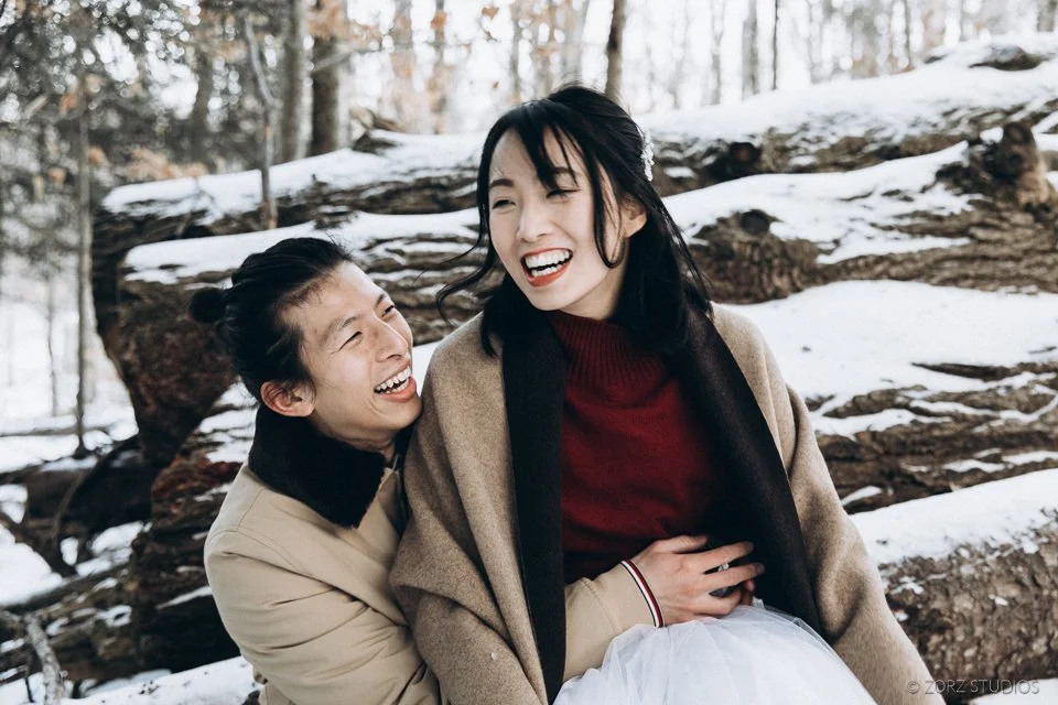 stunning asian couple beams with joy after their winter elopement on a frozen lake