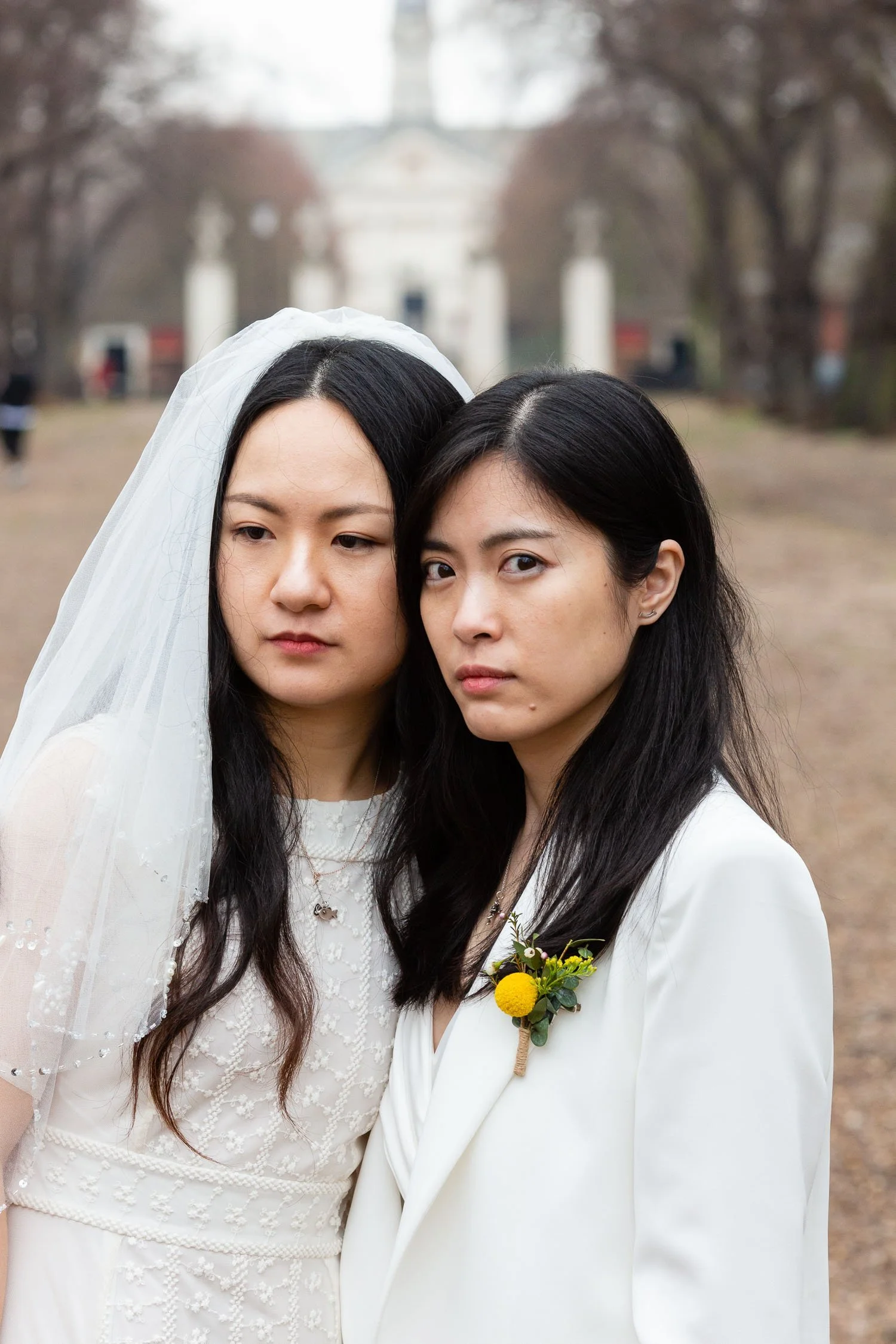 Editorial wedding photo of Japanese women wedding couple, one looking at camera, the other looking to the side