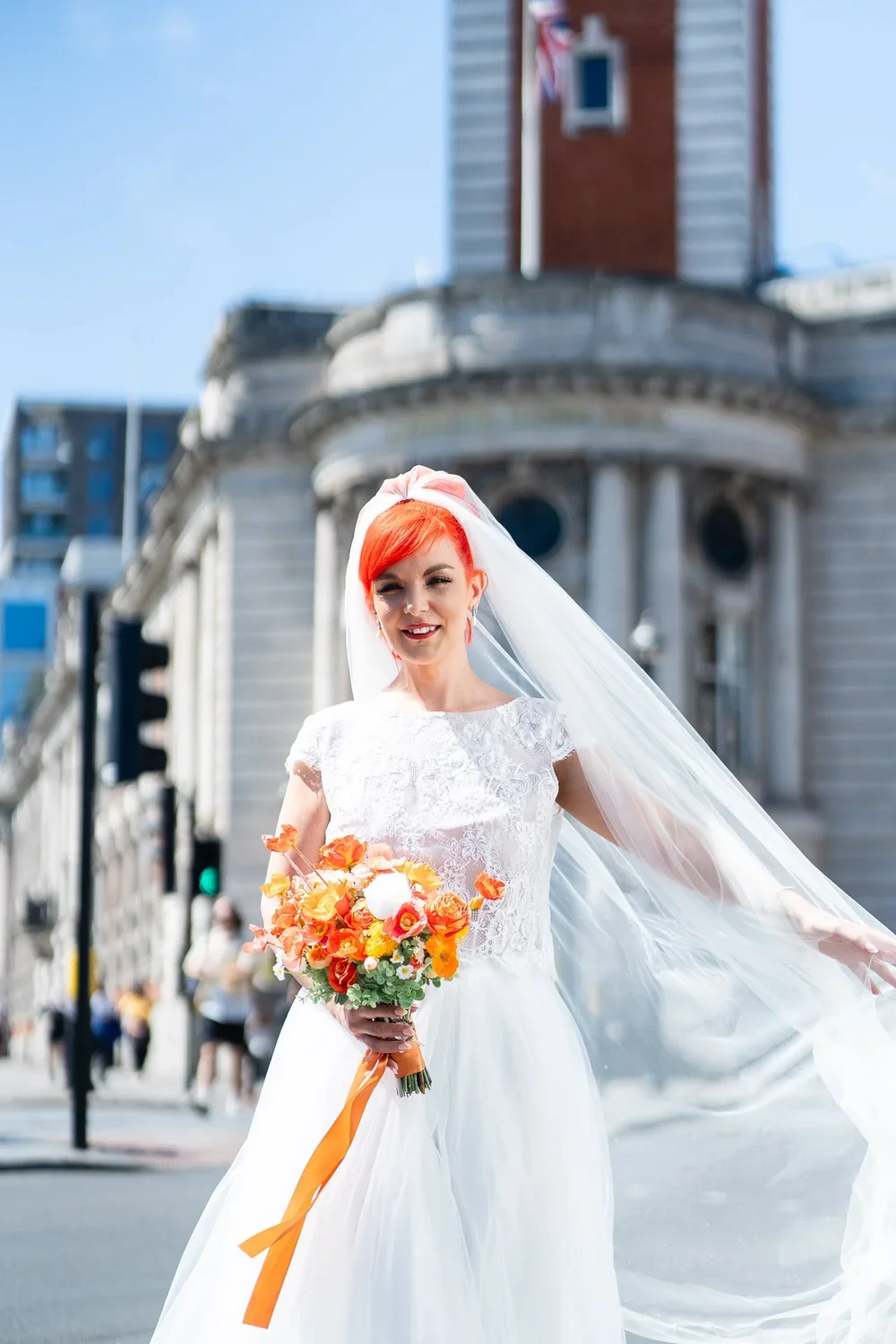 Bride with dyed orange hair draping veil in front of Lambeth Town Hall