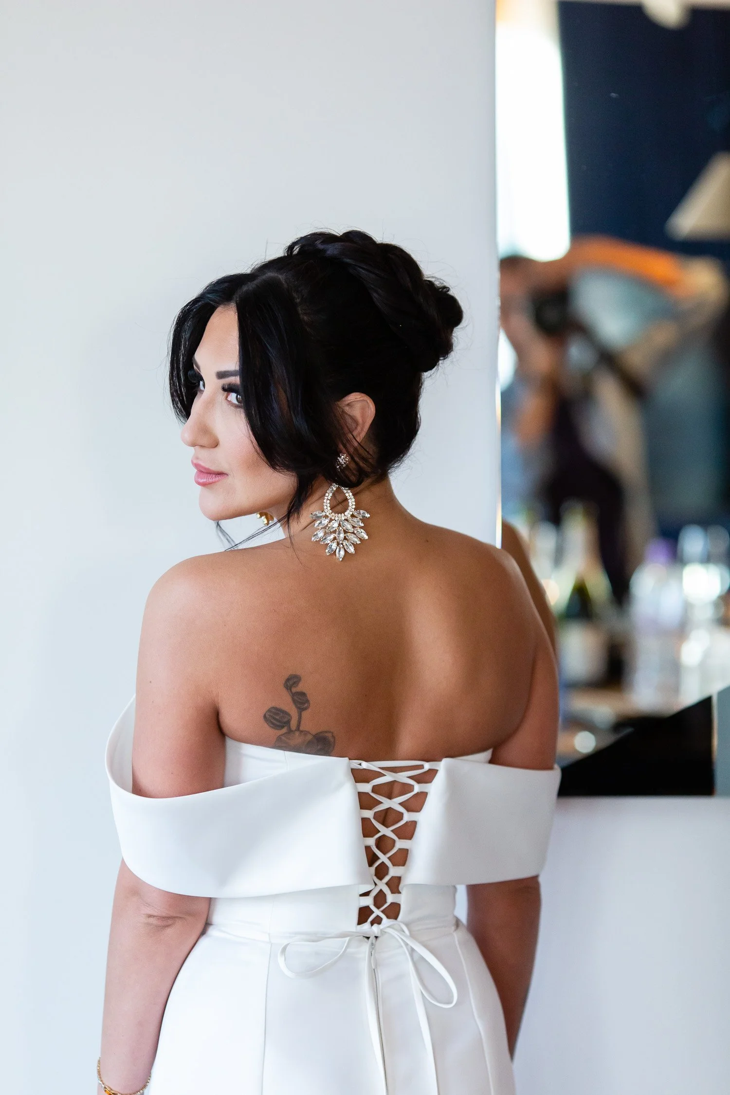 Bride looking over her tattooed shoulder in a posed editorial style