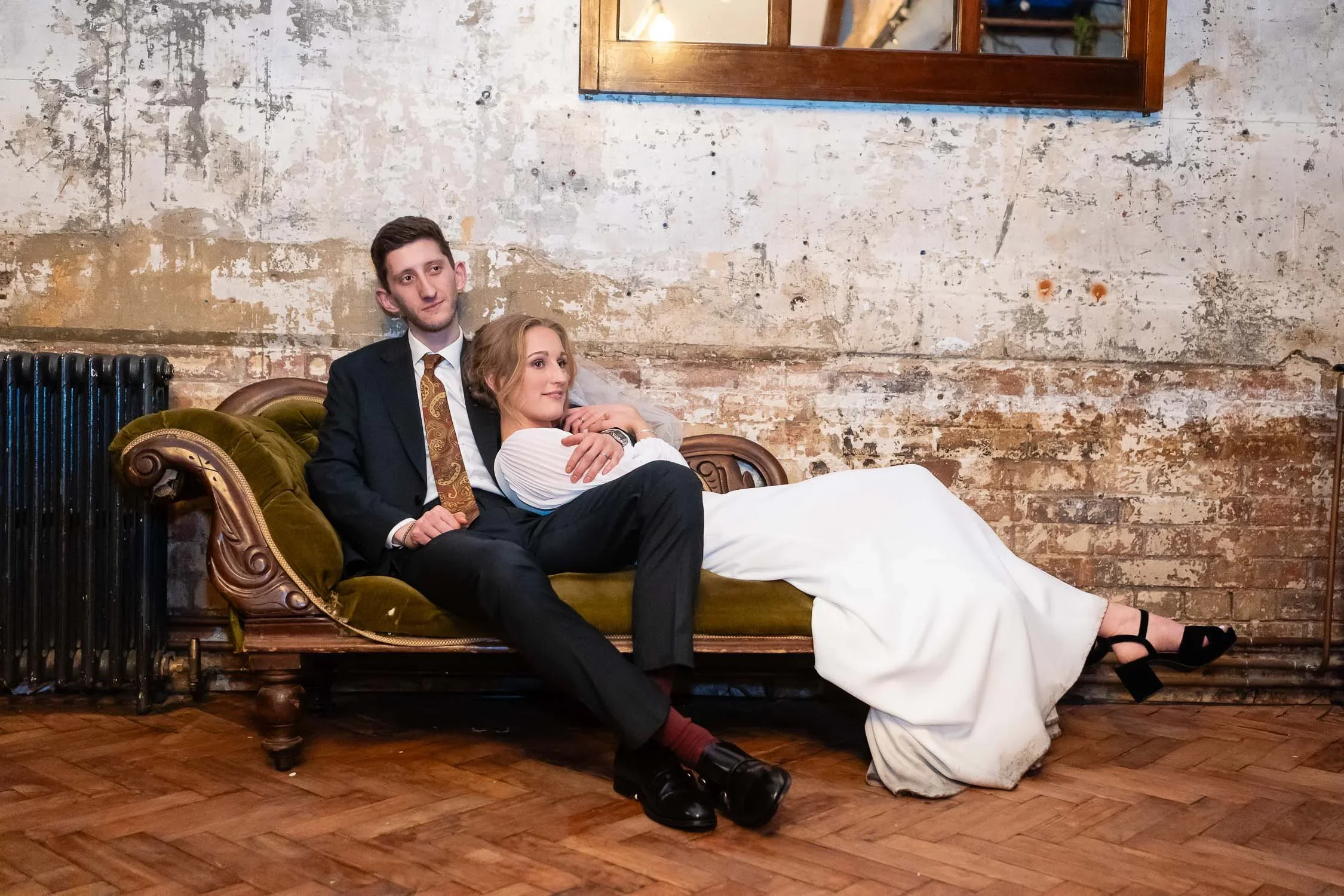 Wedding couple reclining on a chaise longue at Clapton Country Club in editorial wedding photography style